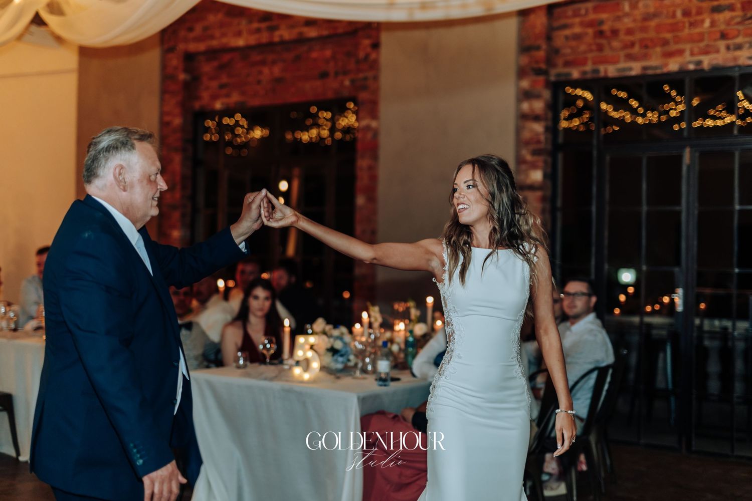 Wedding reception scene with exposed brick walls and ambient lighting.