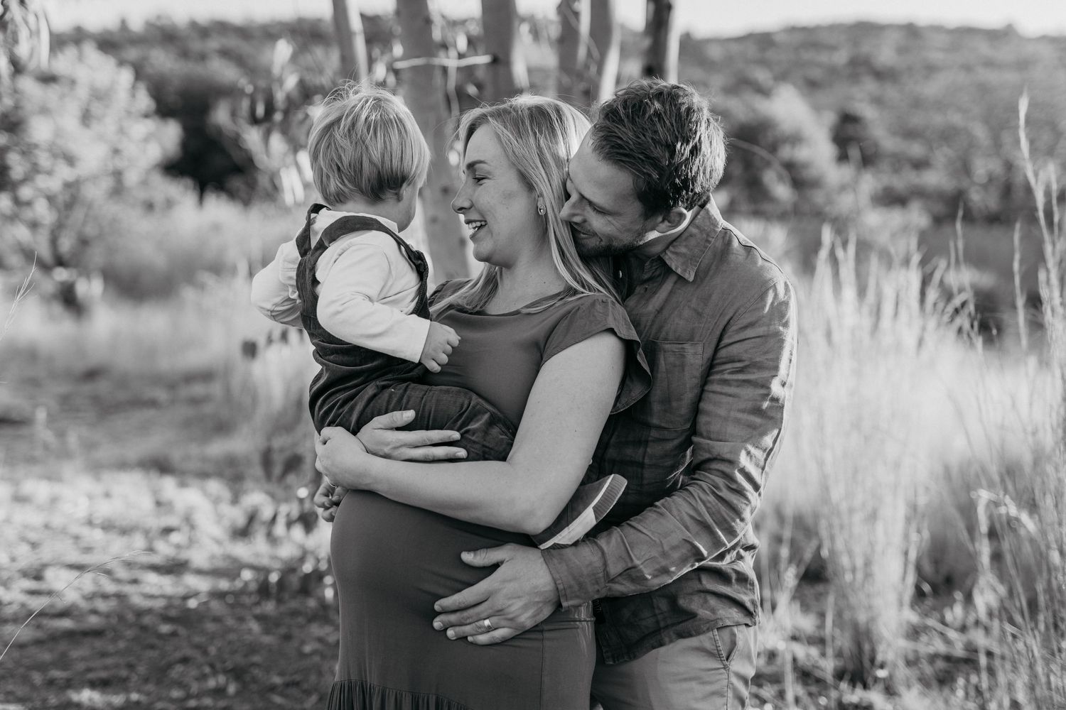 Black and white photo collage showing tender embraces and intimate moments between a couple in an outdoor setting.