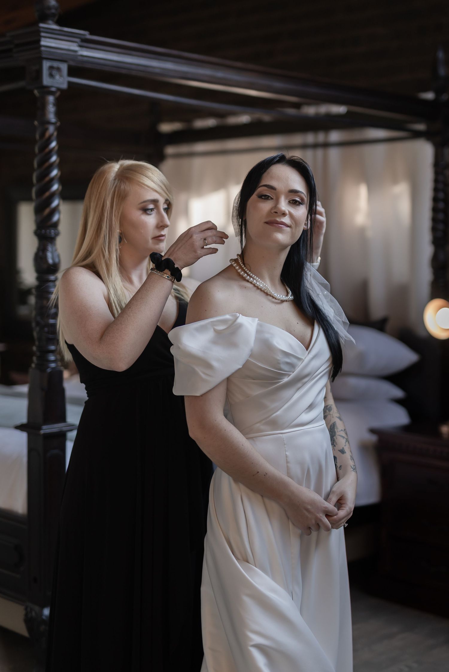 Two people in white dresses share an intimate dance in a dimly lit venue with warm lighting.