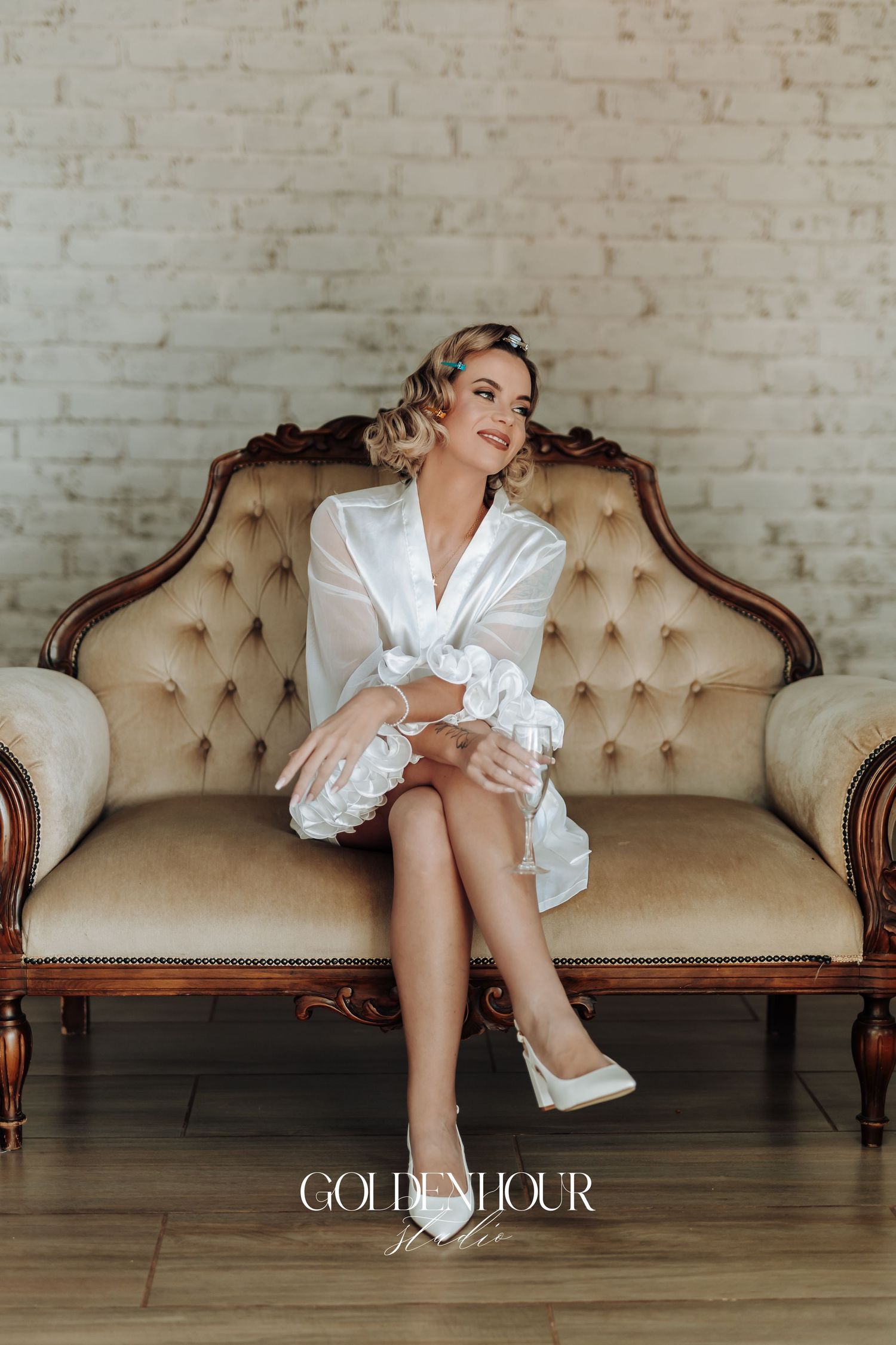 Elegant bridal preparation scene on a vintage tufted couch.
