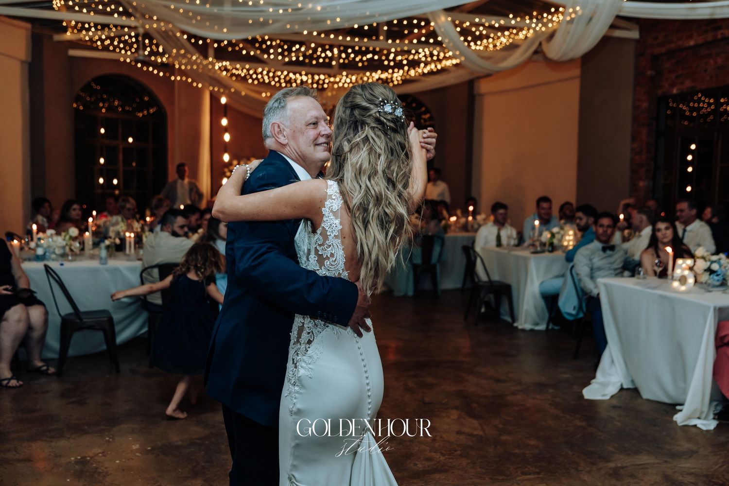 Wedding reception venue decorated with romantic string lights overhead.