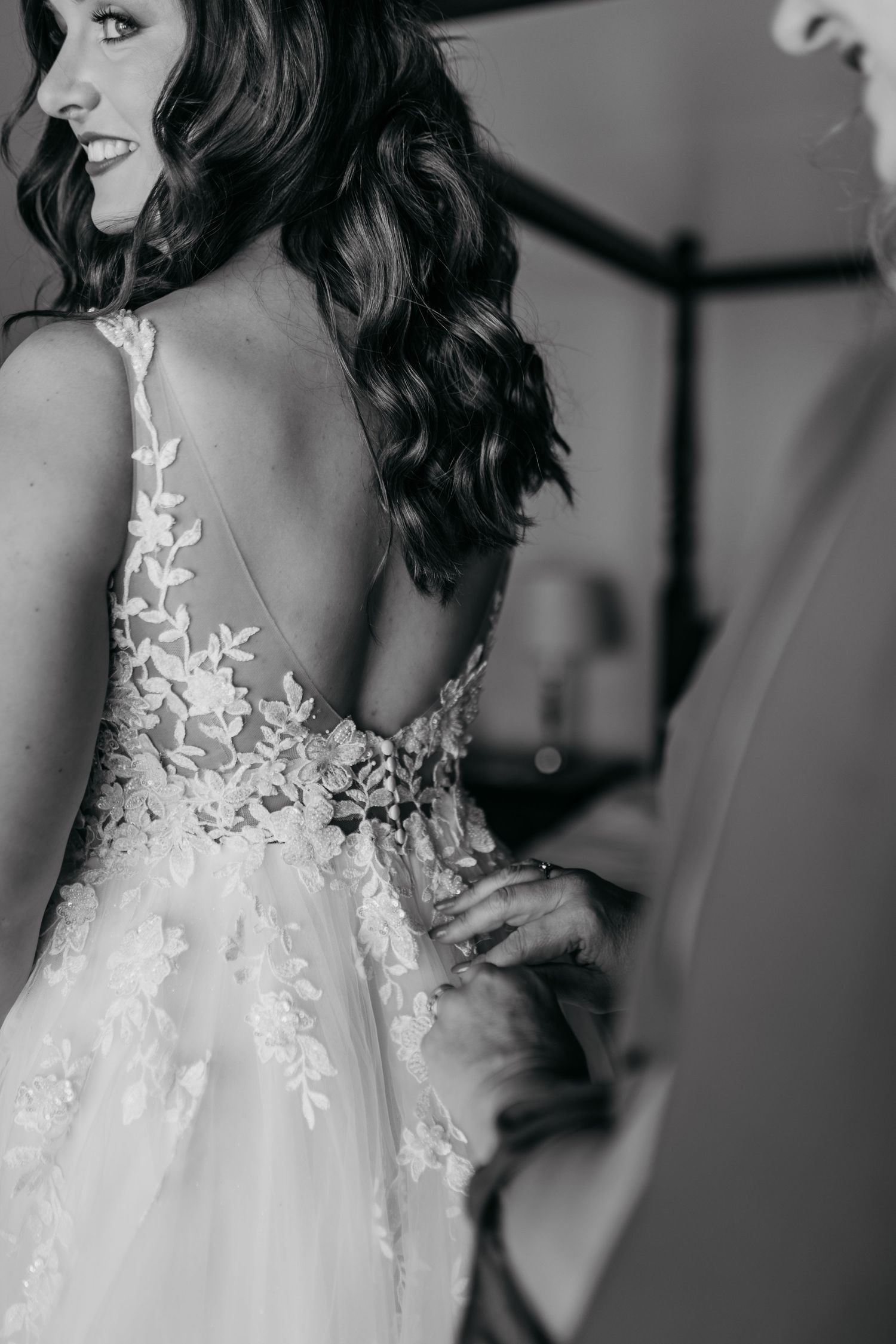 Black and white photo series showing details of a delicate lace wedding dress with floral appliques.