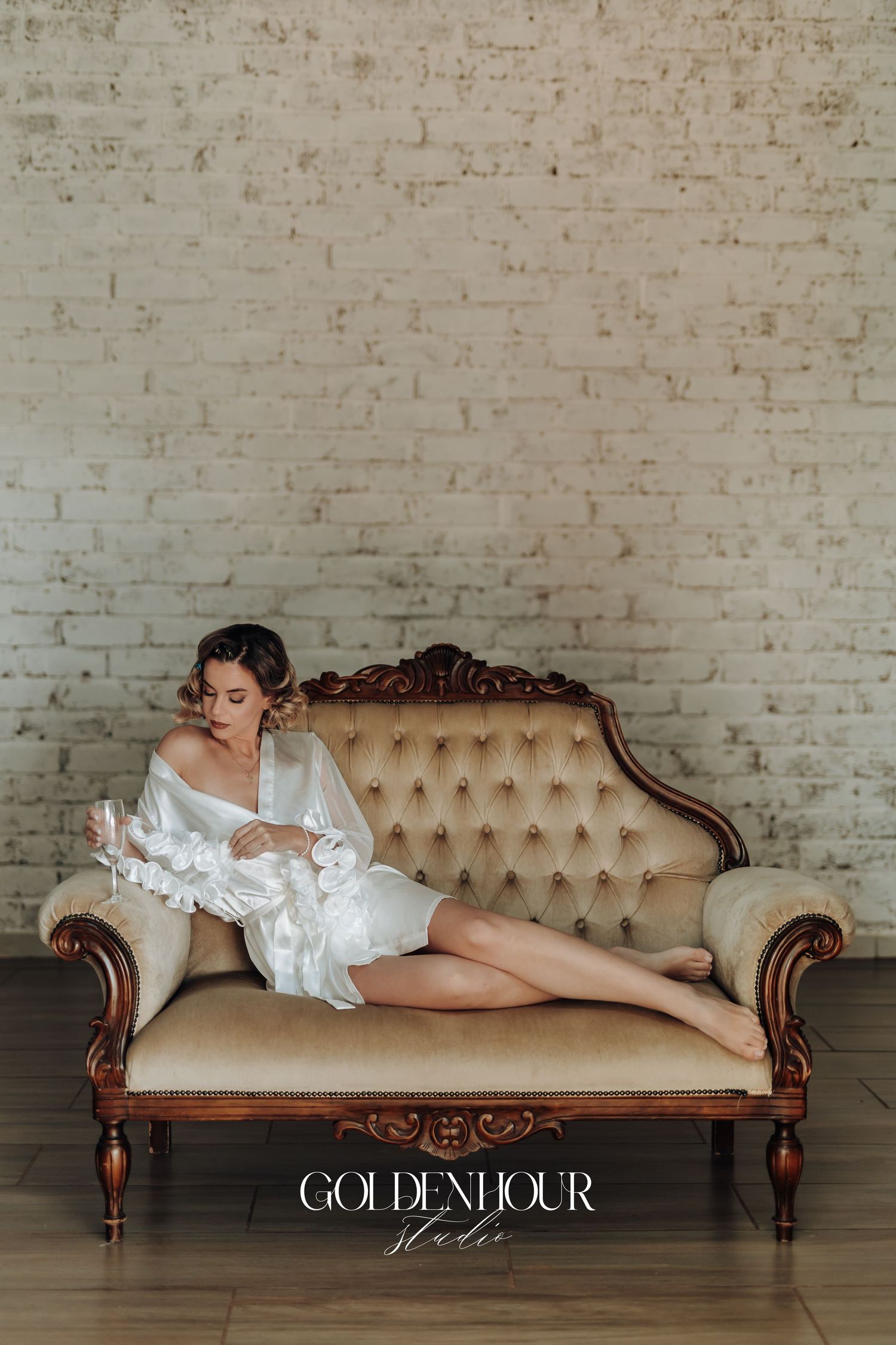 Elegant boudoir photos featuring white silk robe poses on a vintage tufted chaise lounge.