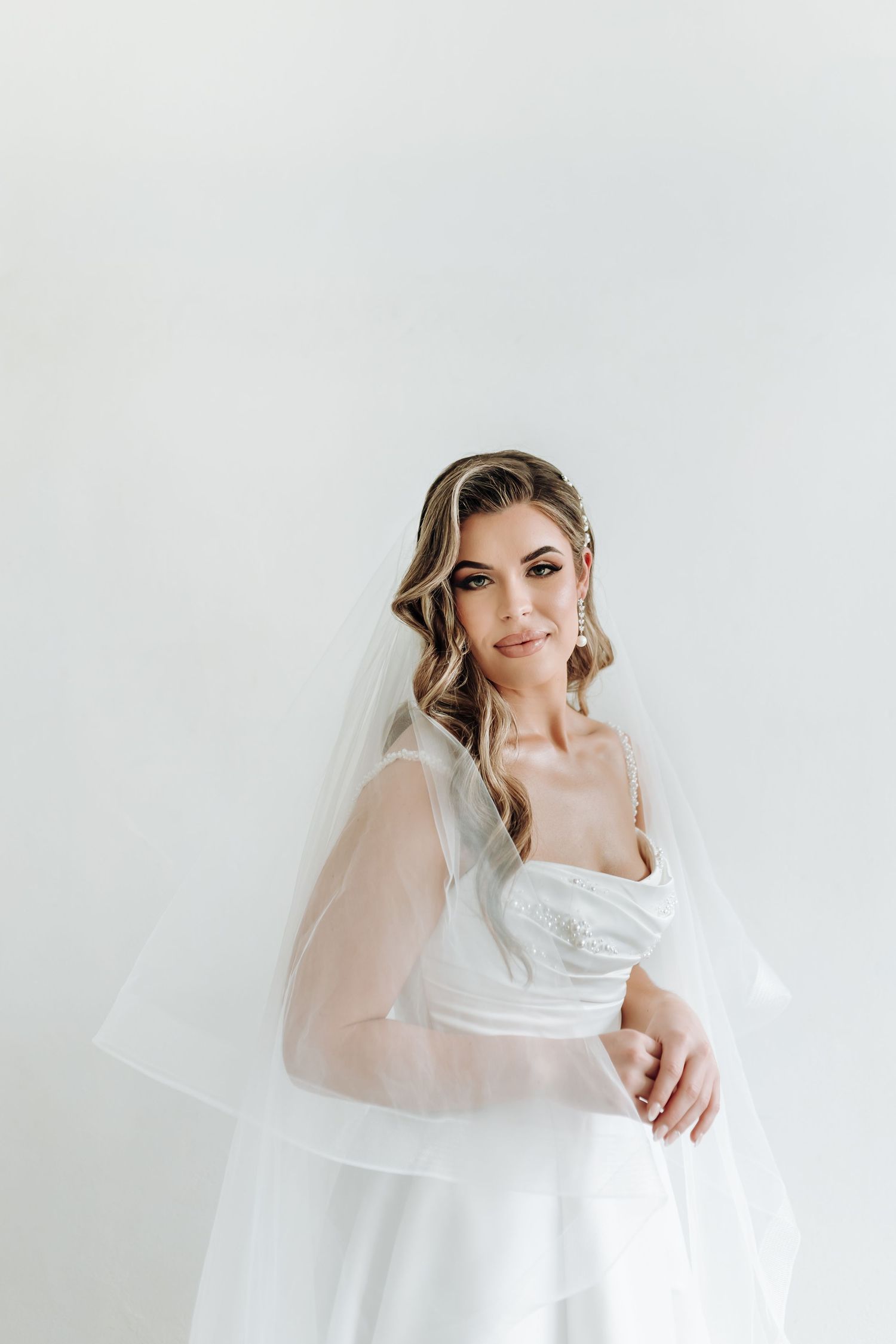 Elegant bridal portraits against white background with flowing veil.