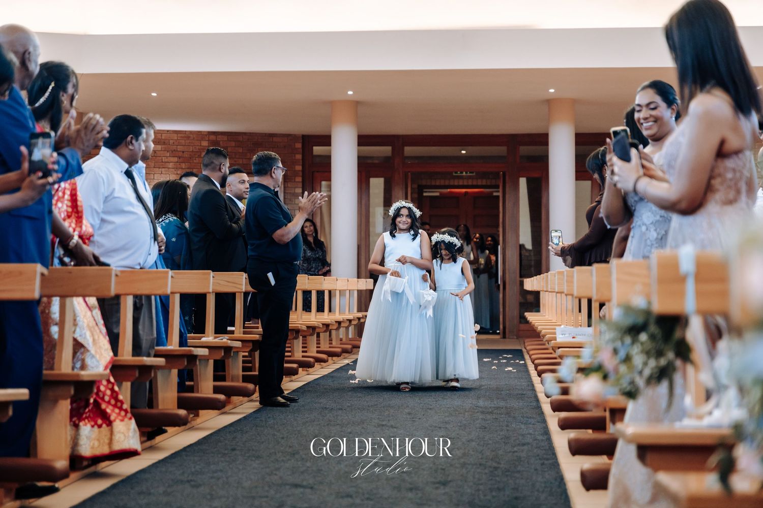 Wedding ceremony in progress at an indoor venue with guests seated in rows.