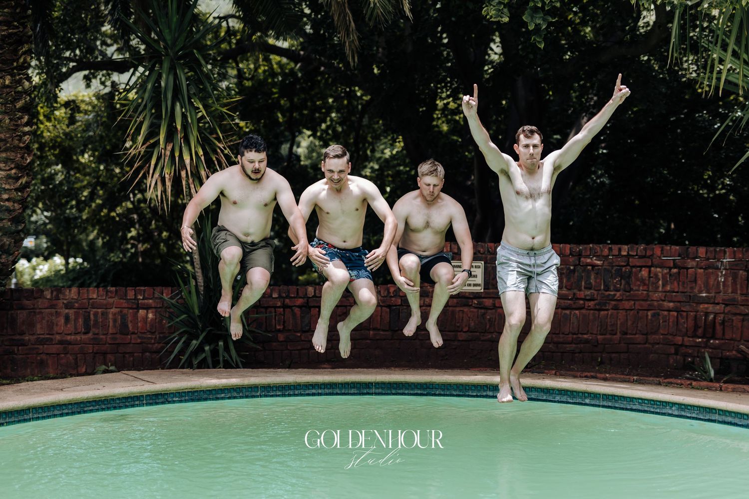 Friends jumping into a swimming pool on a sunny day during a summer celebration.