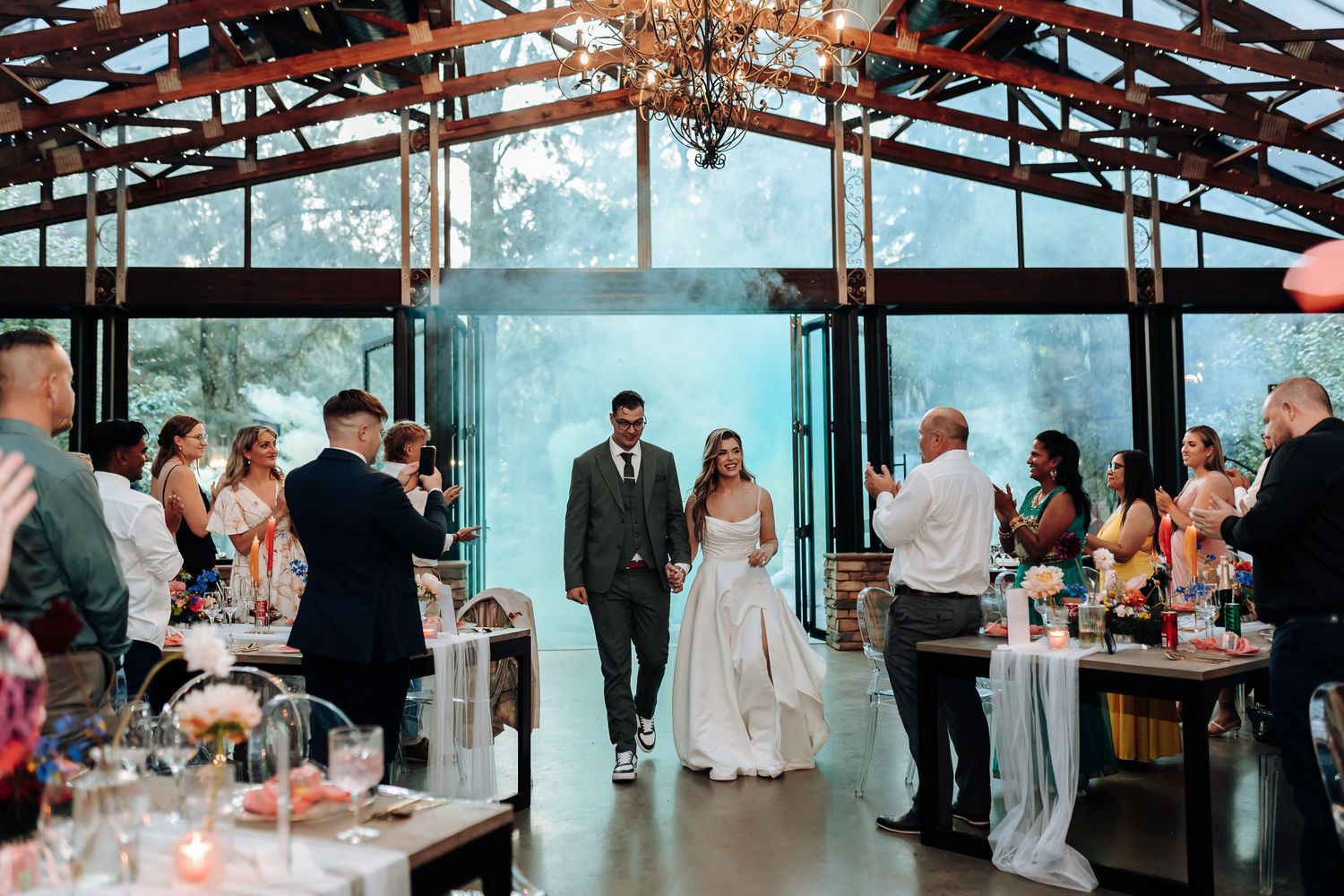 Guests mingling at a modern event venue with floor-to-ceiling windows and blue ambient lighting.
