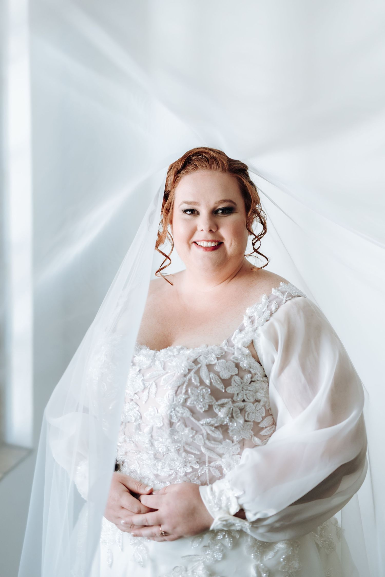 A bride in a white lace wedding gown with billowing sheer sleeves poses against a light background in four elegant shots.