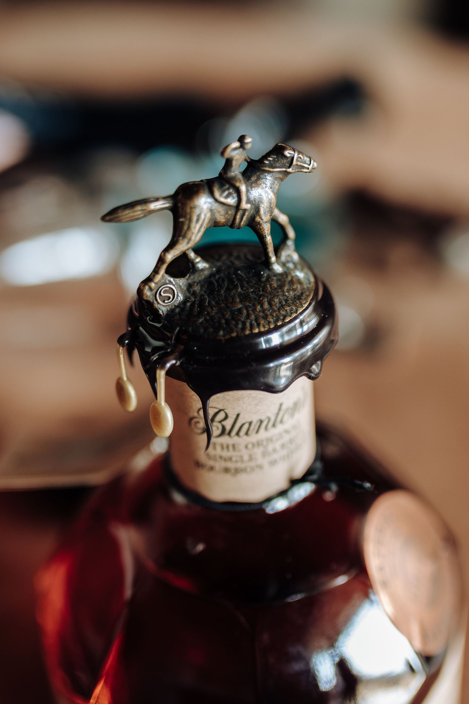 Macro photography shows vintage apothecary bottle tops with ornate metal lids against a warm brown and red background.