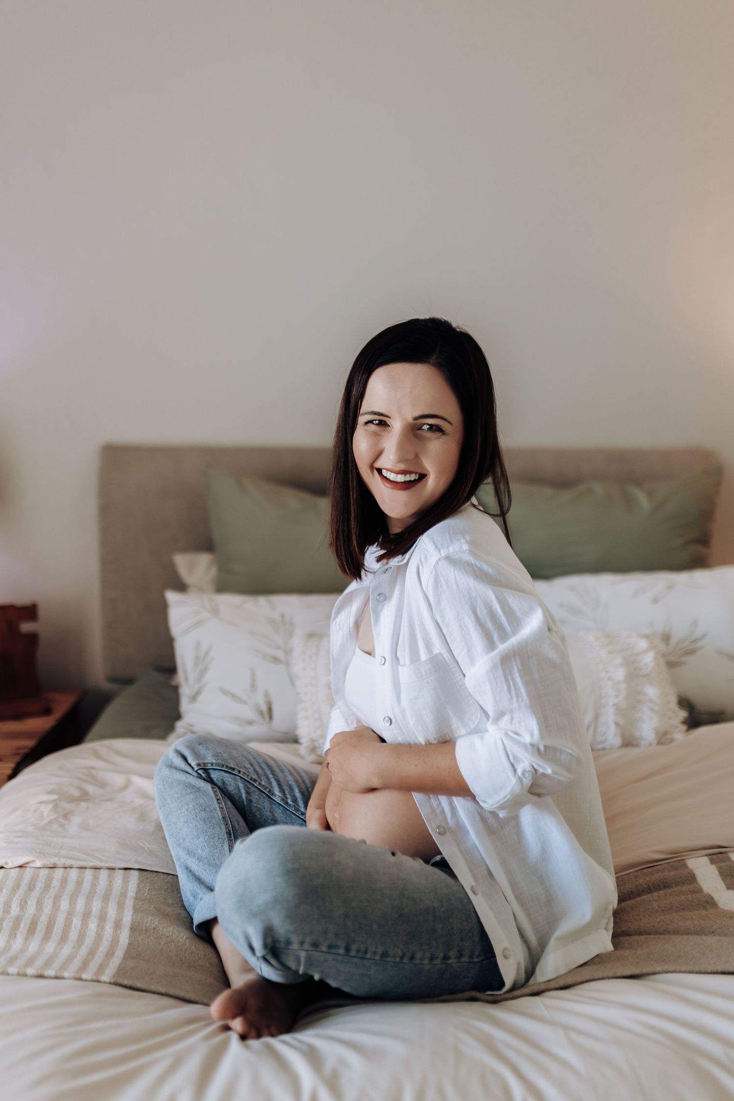 A sequence of lifestyle photos showing someone relaxing on a bed wearing a white blouse and gray jeans.