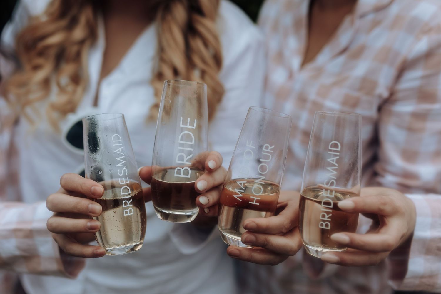 Close-up of hands holding champagne glasses for a celebratory toast.