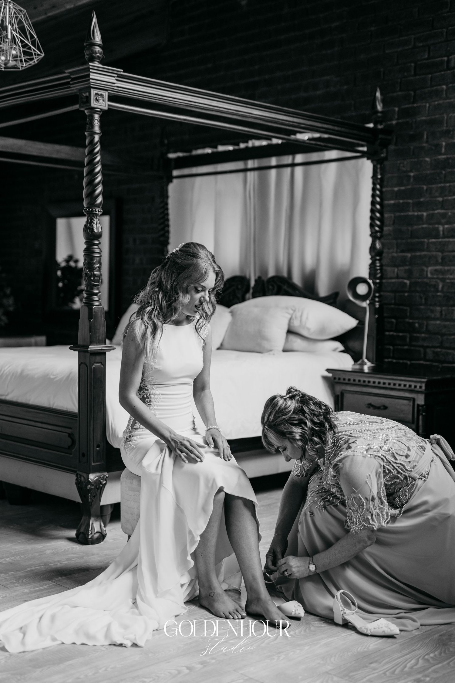 Black and white intimate wedding moment captured on antique four-poster bed.