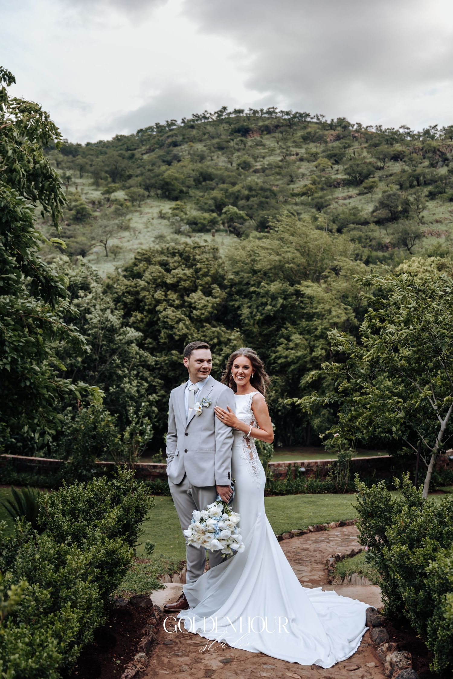 A romantic wedding photoshoot in a lush mountain setting with natural greenery and scenic views.