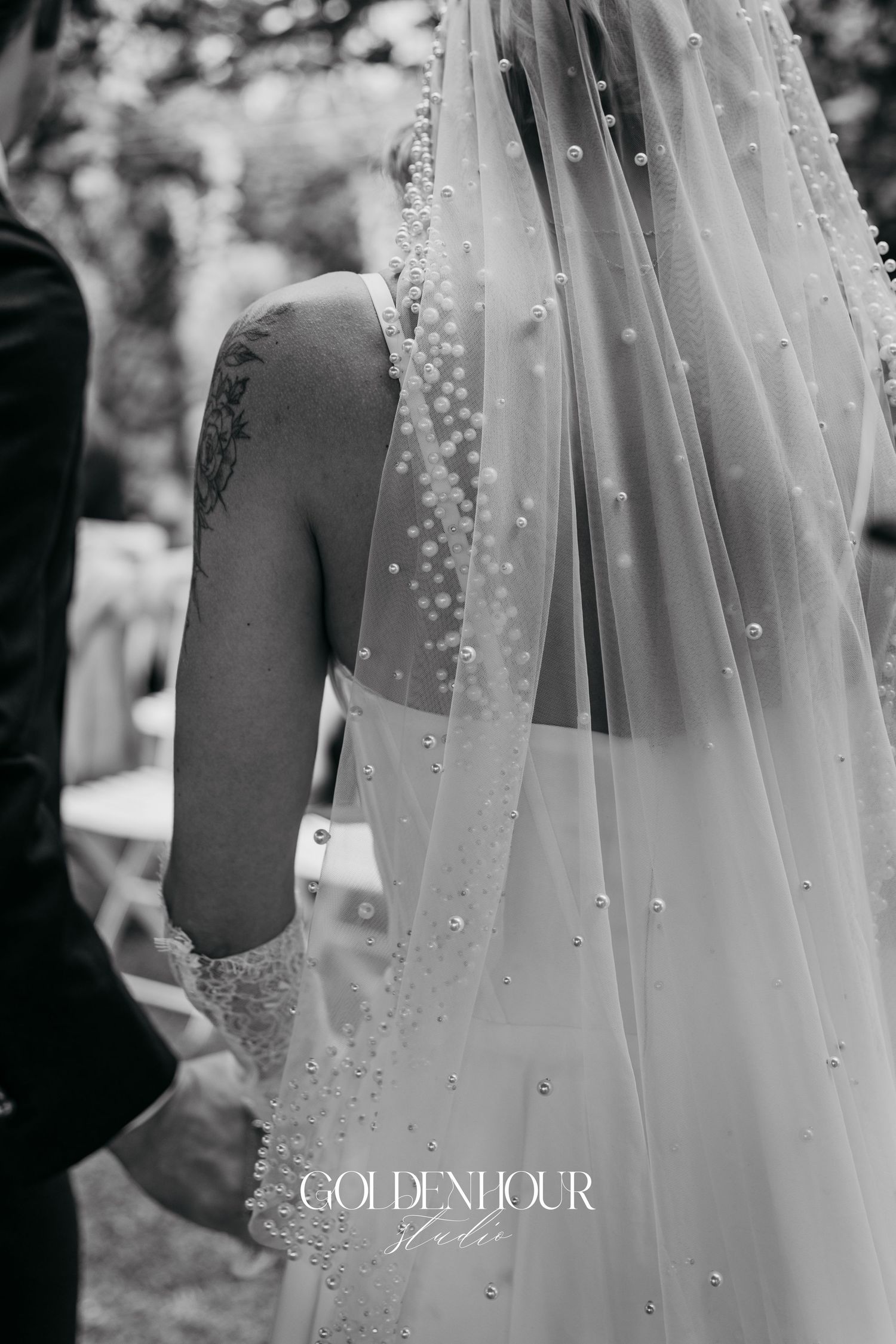 Close-up of delicate pearl-embellished wedding veil in black and white.