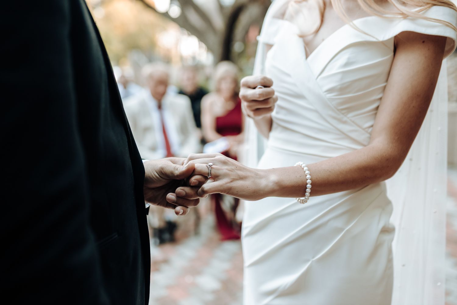 Close-up of hands exchanging rings during a wedding ceremony.