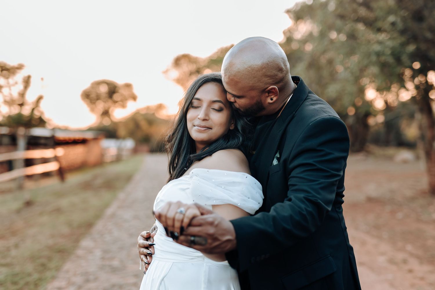 Tender embrace captured during golden hour wedding photography session outdoors.