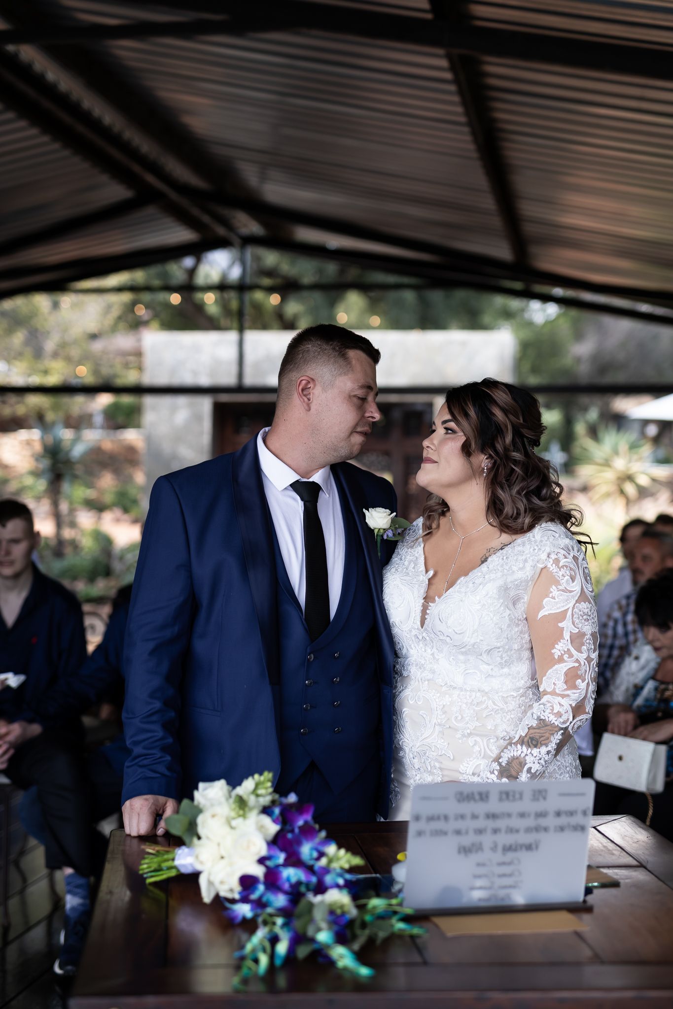 A tender moment between newlyweds during their outdoor pavilion wedding ceremony.