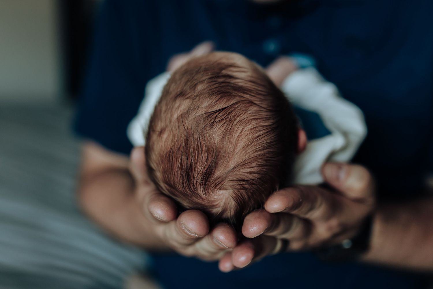 A series of intimate black and white close-up photographs showing tender family moments with a newborn baby.
