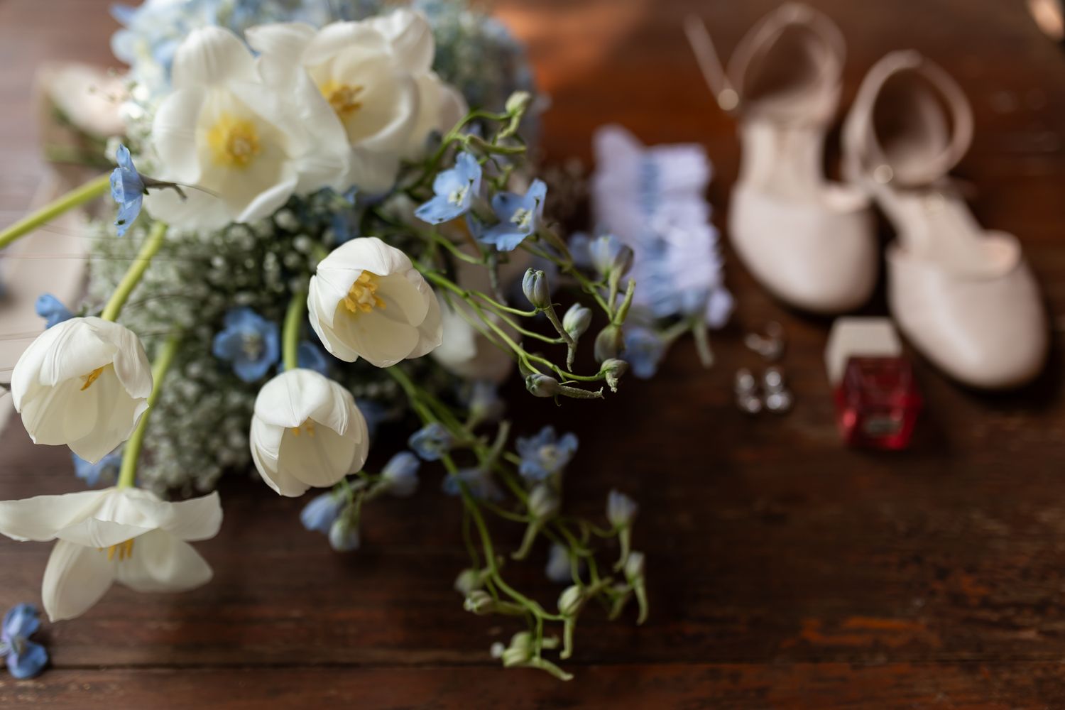 Wedding detail photo with white roses and blue flowers in a delicate arrangement.