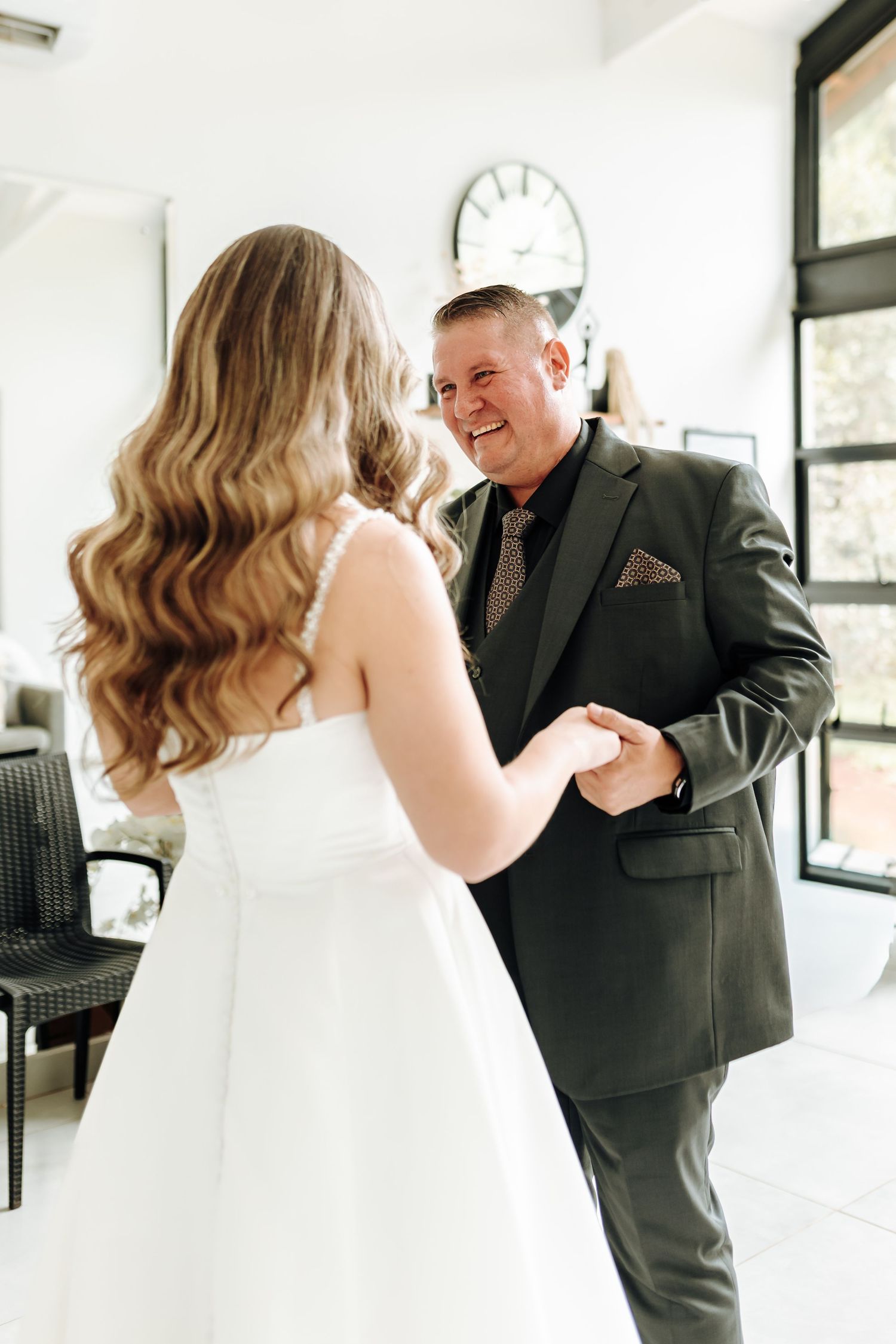 A heartwarming moment captured during wedding preparations in a bright, modern interior.