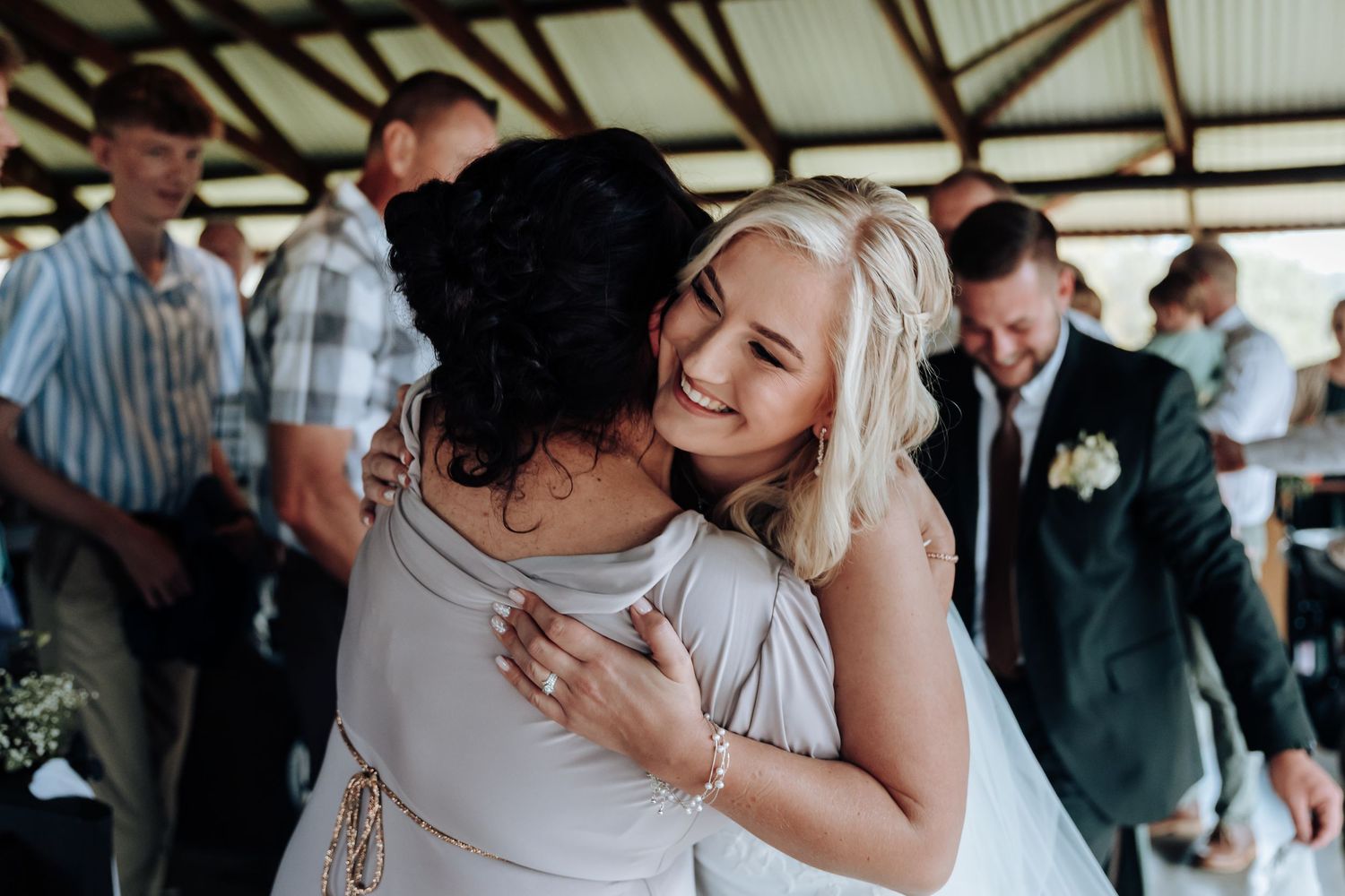 Newlyweds embrace on the dance floor during their first dance at an indoor wedding reception.