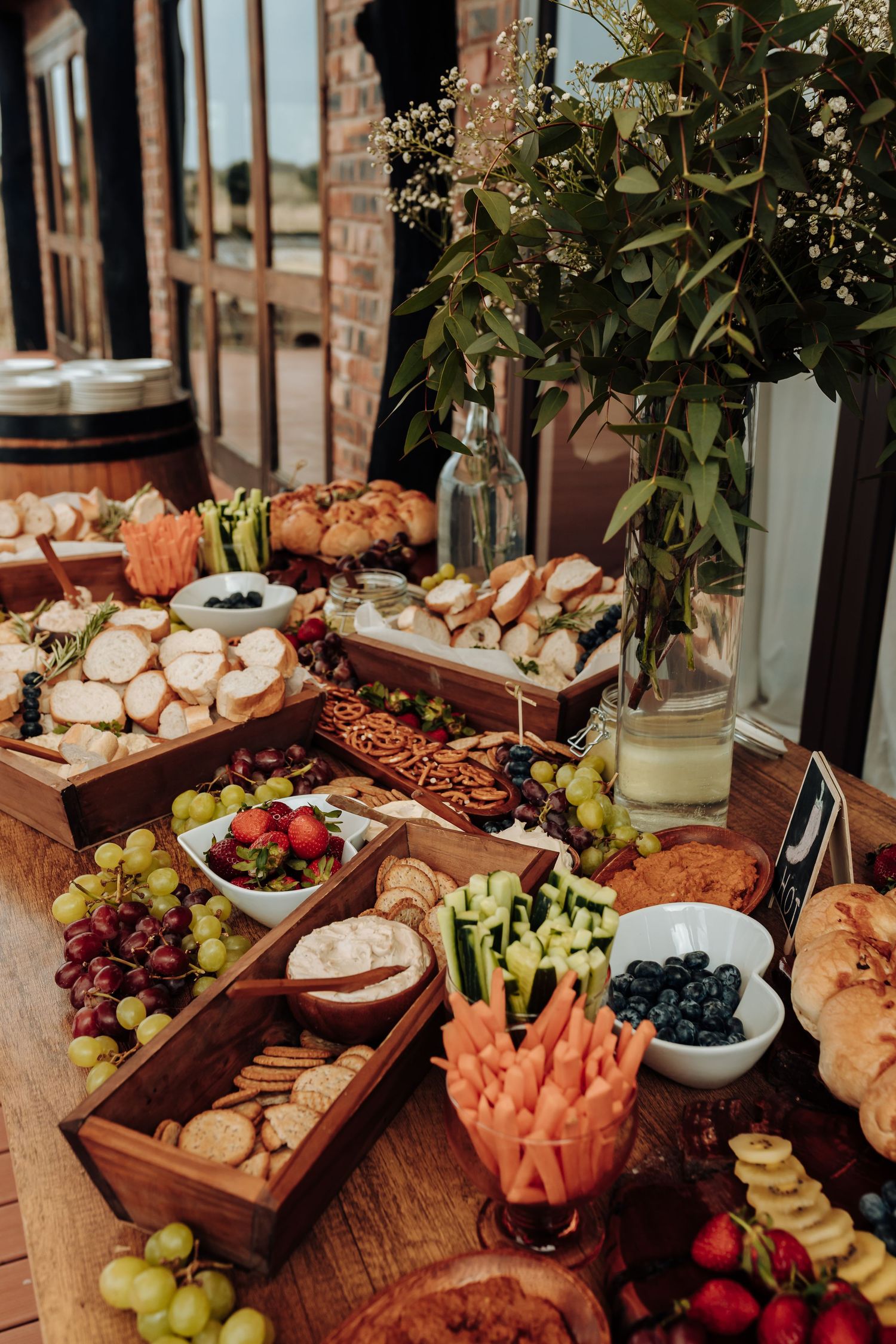 Rustic wooden boards filled with a colorful array of fruits, cheeses, grapes, crackers, and charcuterie for entertaining.