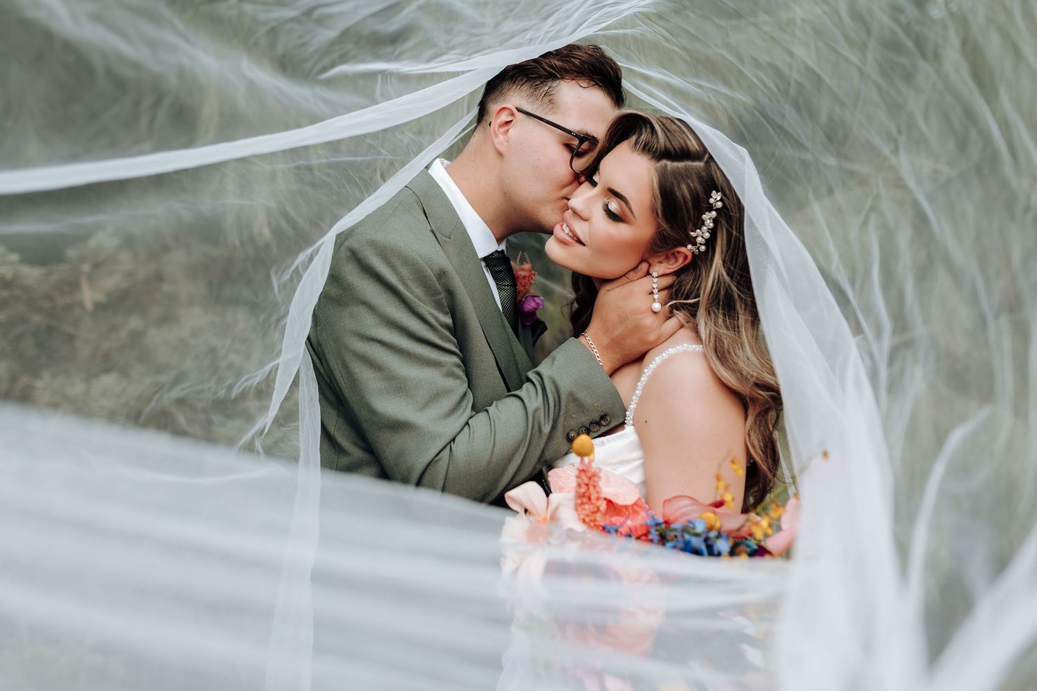 A romantic wedding couple shares intimate moments in a series of elegant outdoor portraits.