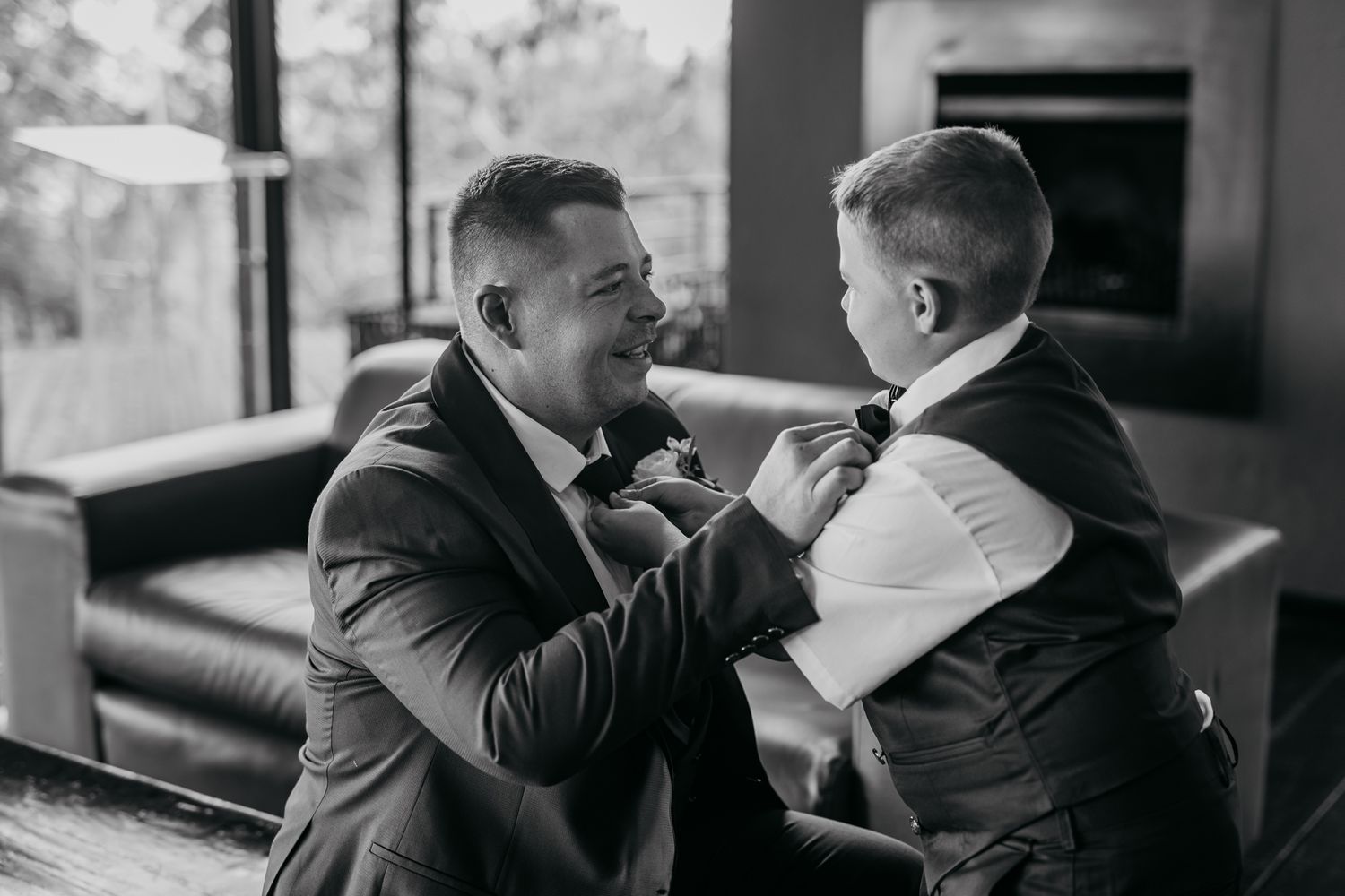 Black and white intimate moment between two people adjusting formal attire.