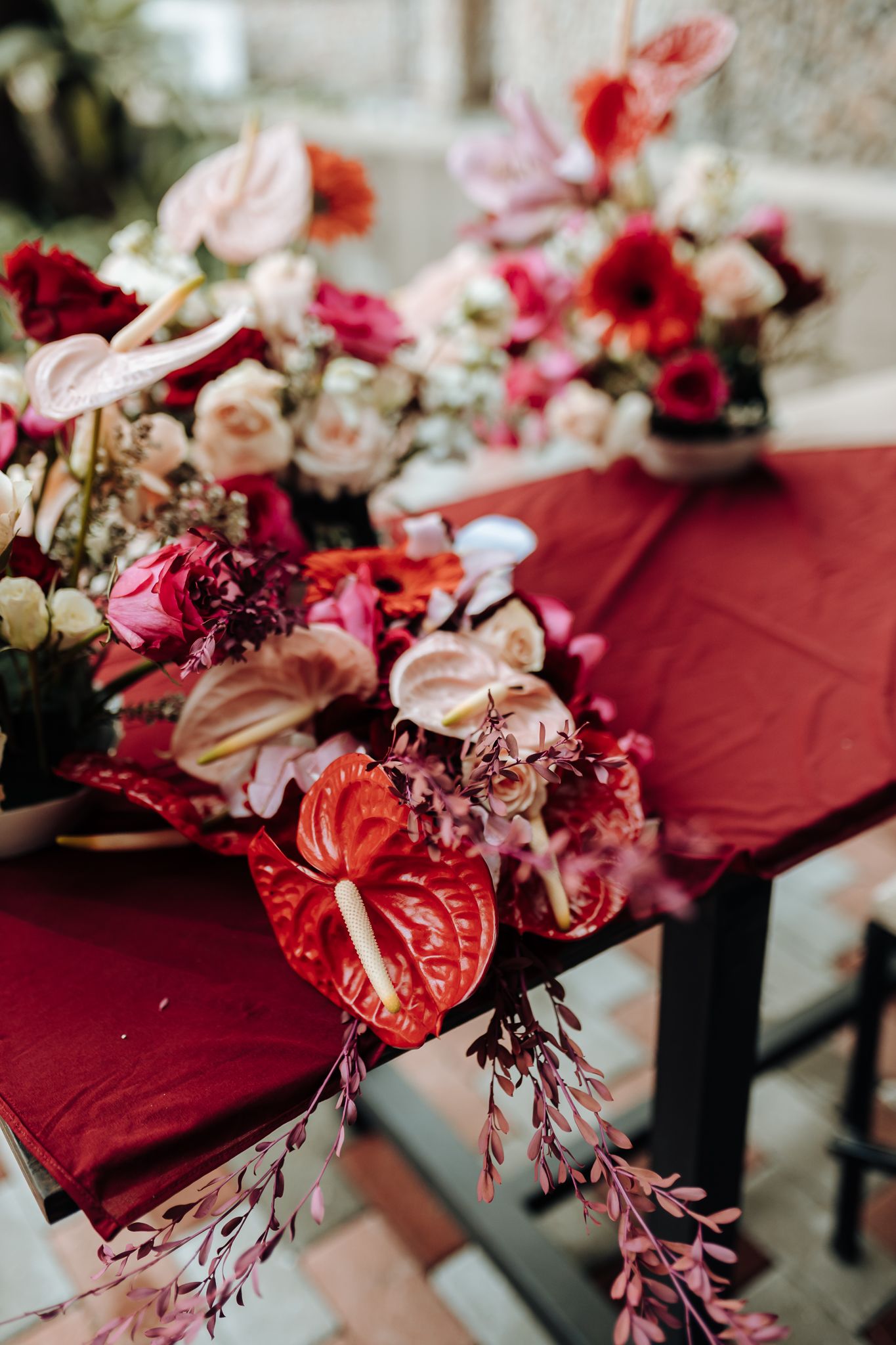 A wedding ceremony moment under an elegant burgundy and copper draped arch.