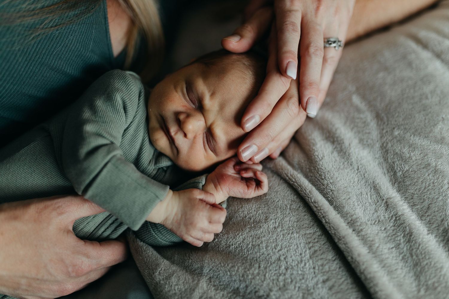 Hands comforting and holding onto another person in a candid emotional moment.