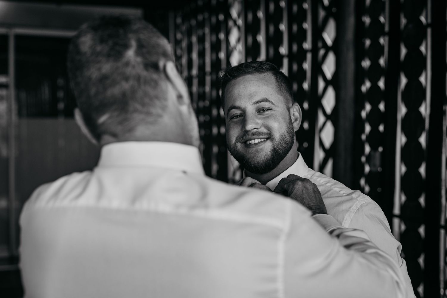 A sequence of black and white photos showing people laughing and hugging at a joyous celebration.