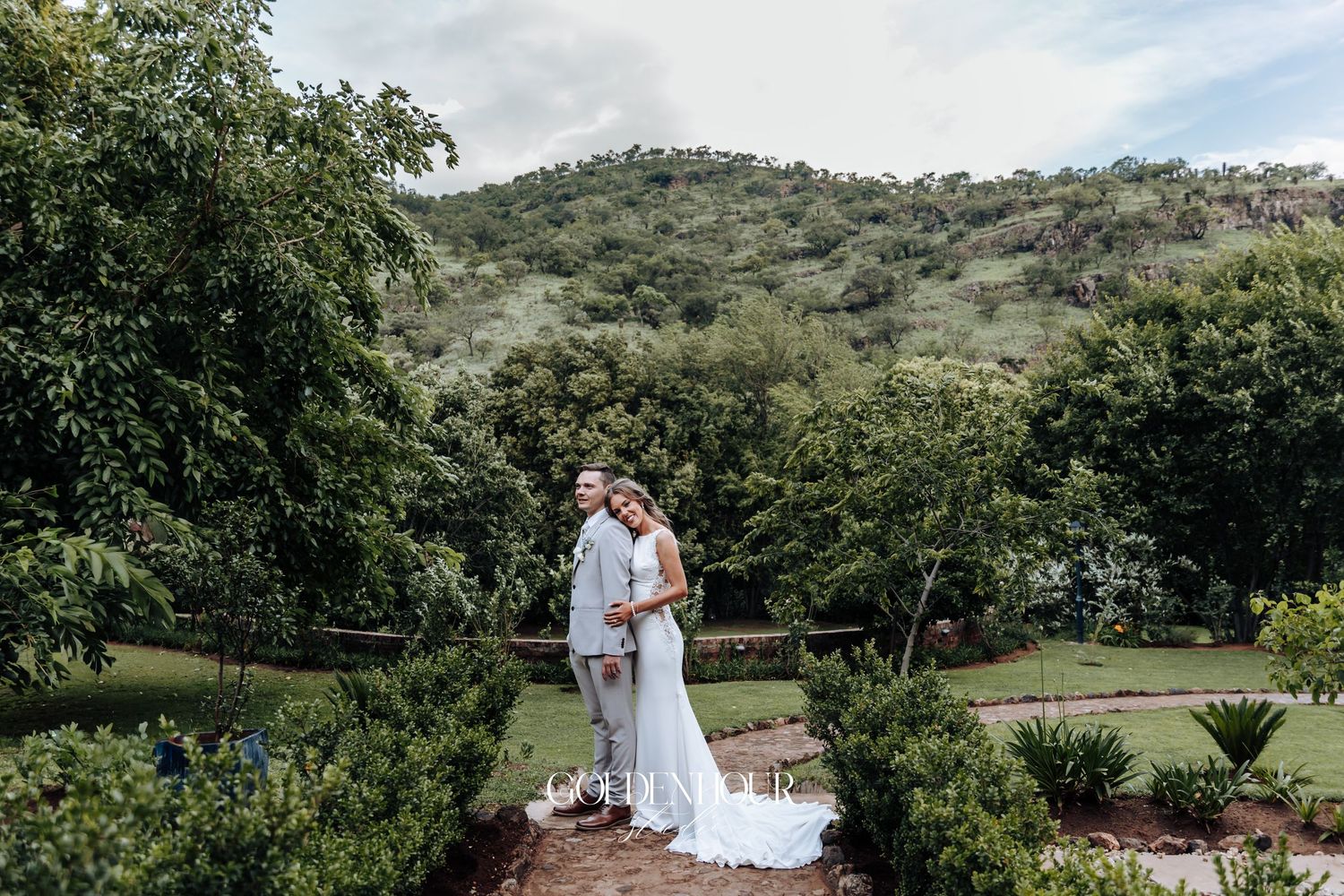 A scenic wedding photo overlooking rolling hills and lush greenery.