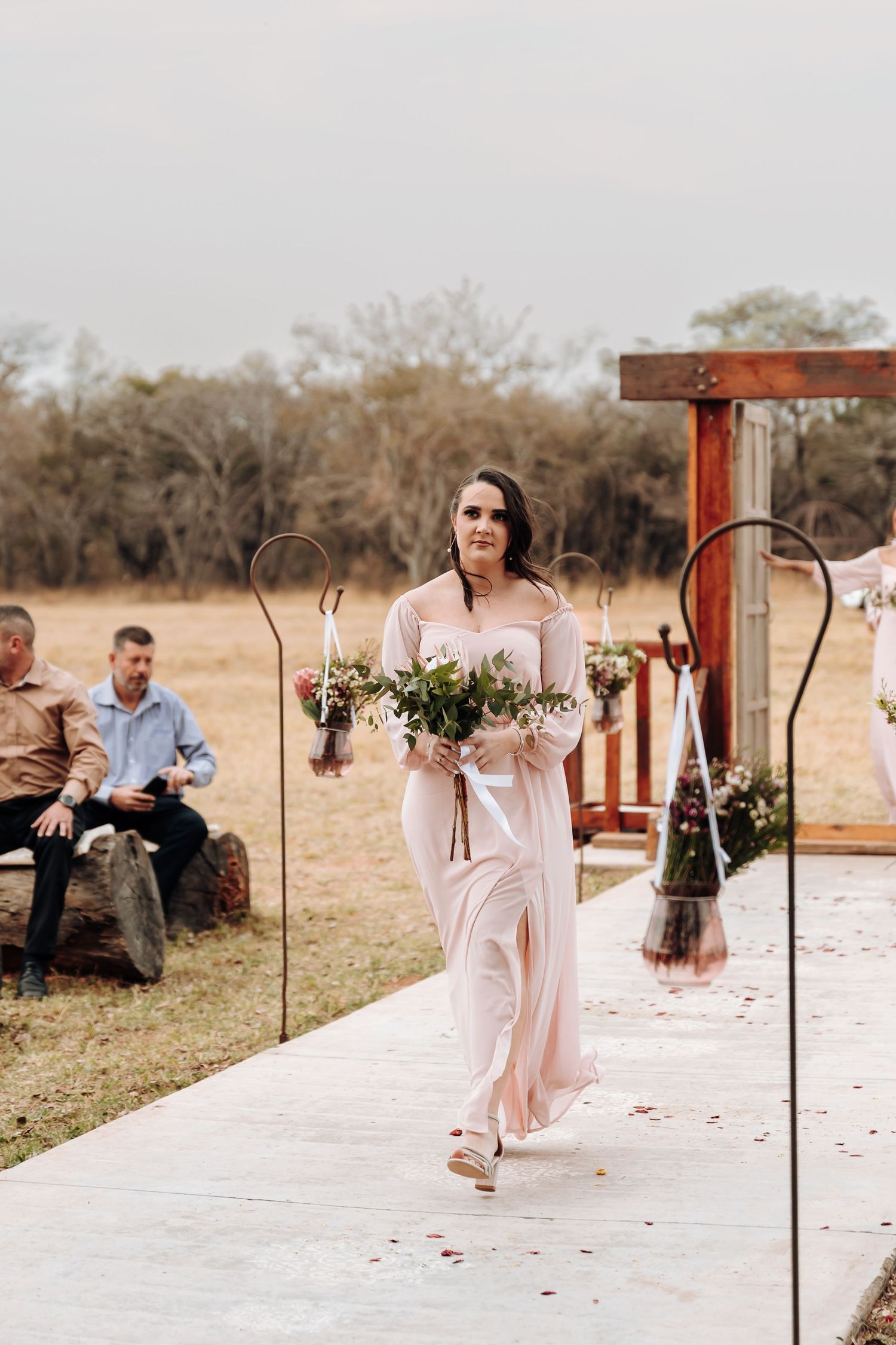 A sequence of wedding scenes with someone gracefully tossing rose petals along a white aisle outdoors.