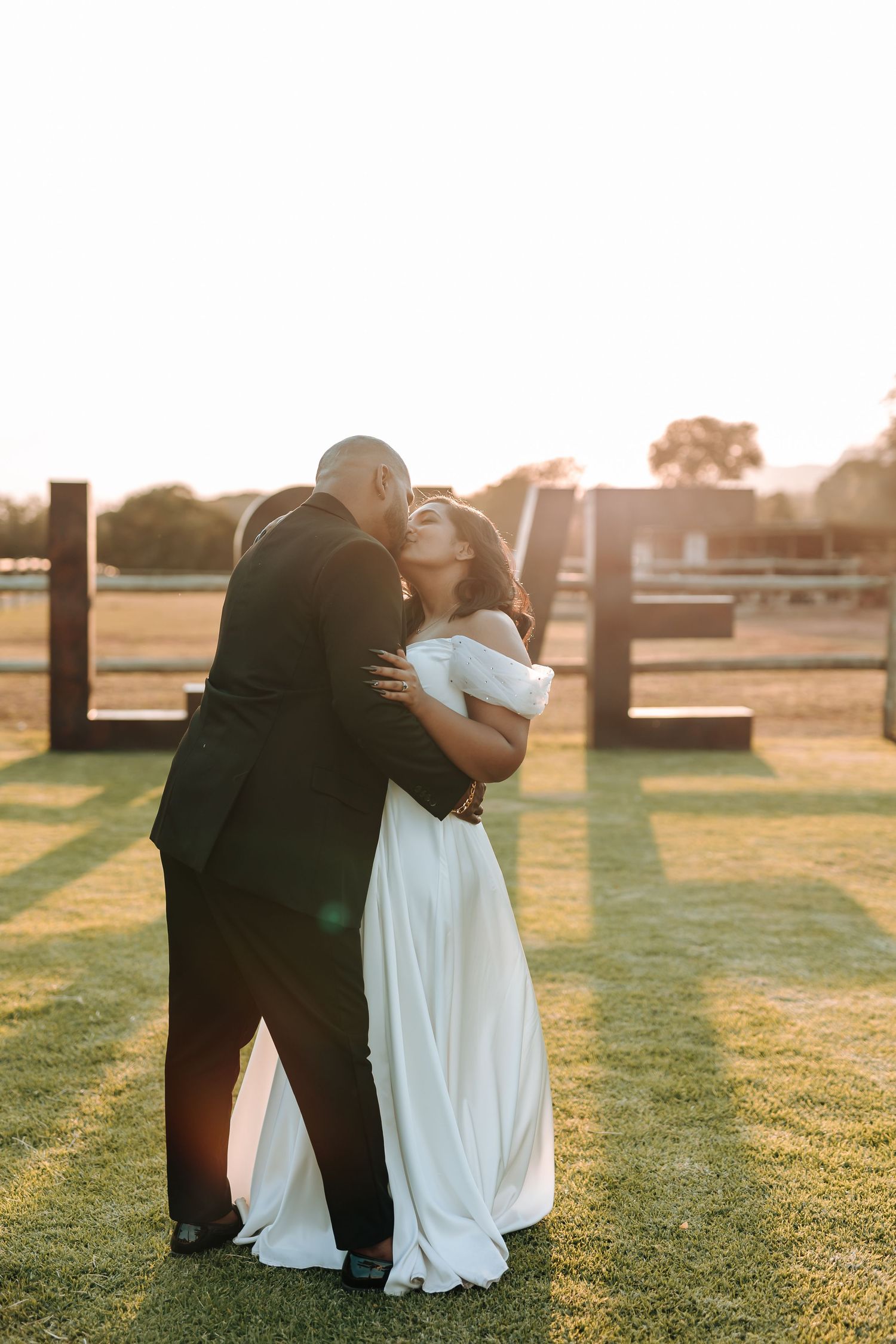 A couple shares a joyful embrace during their sunset wedding photoshoot.