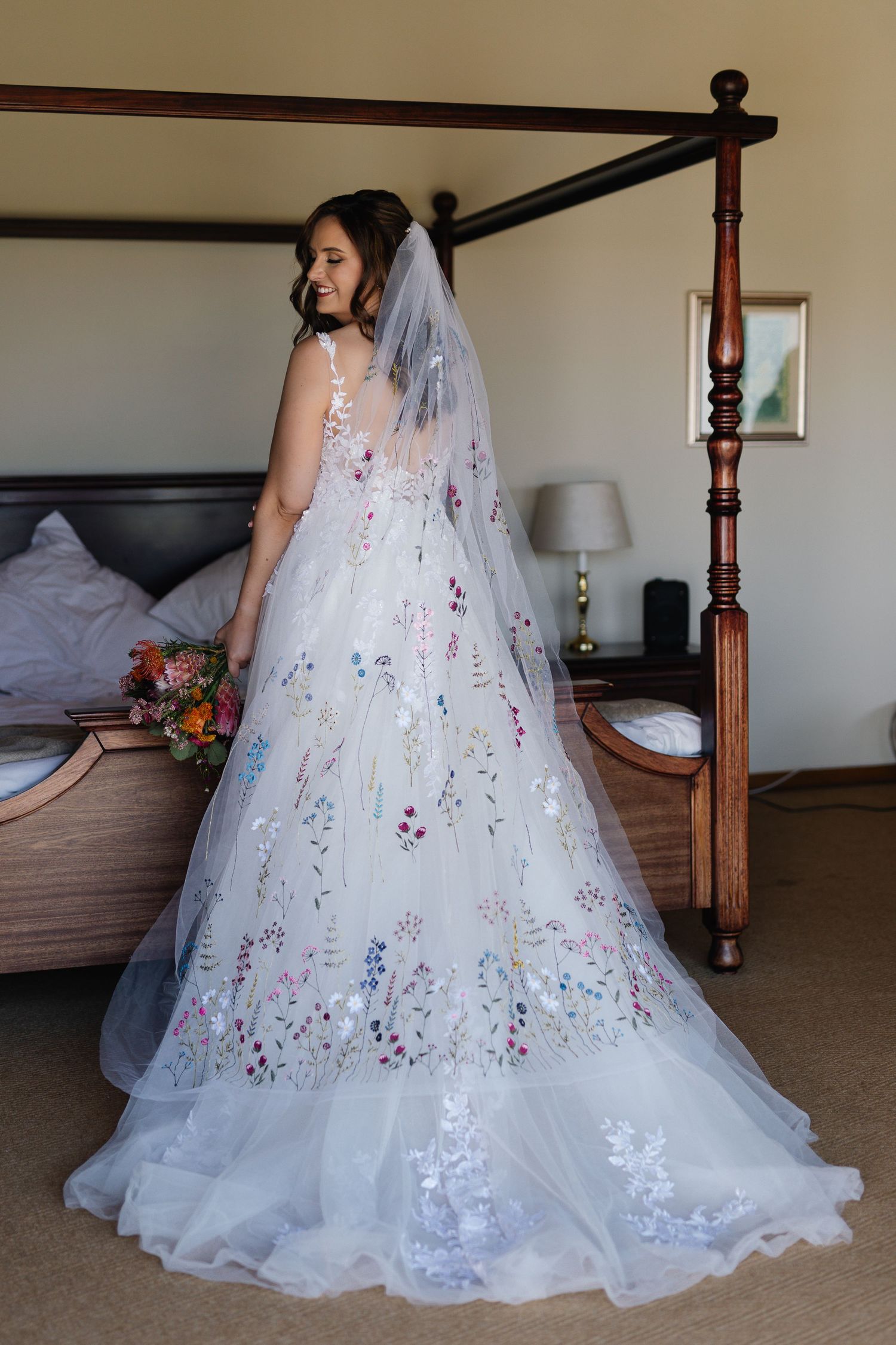 A stunning floral embroidered wedding gown with delicate white tulle and colorful floral details shown from multiple angles.