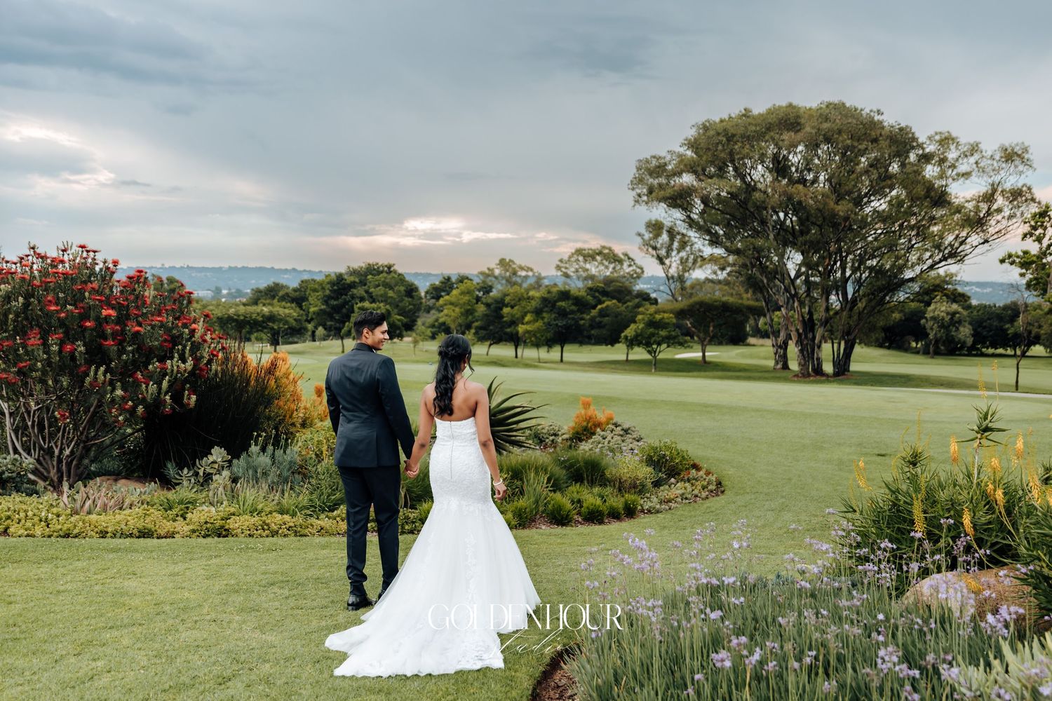 Panoramic view of a garden wedding venue with flowering plants and green landscape.