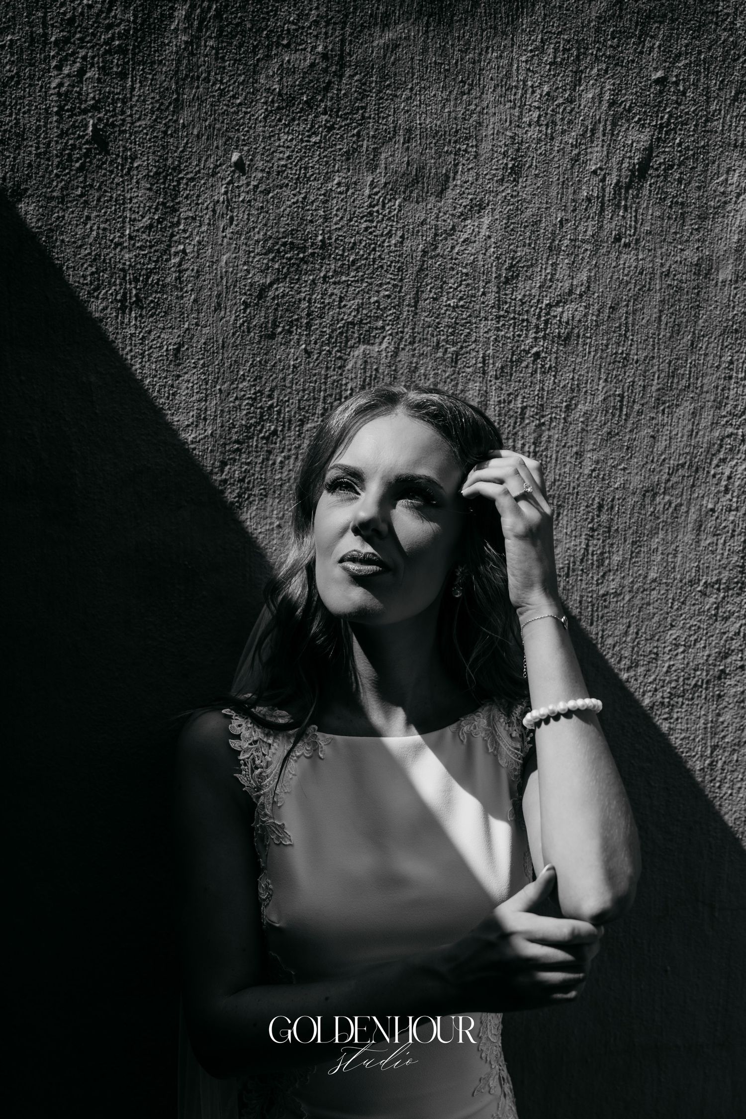 Dramatic black and white portrait series showing artistic shadows and lighting against a textured wall.