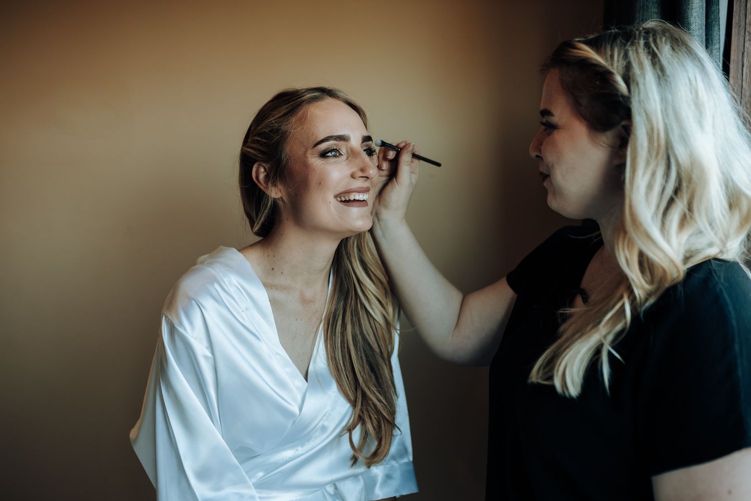 Wedding day makeup preparation scene in warm ambient lighting.
