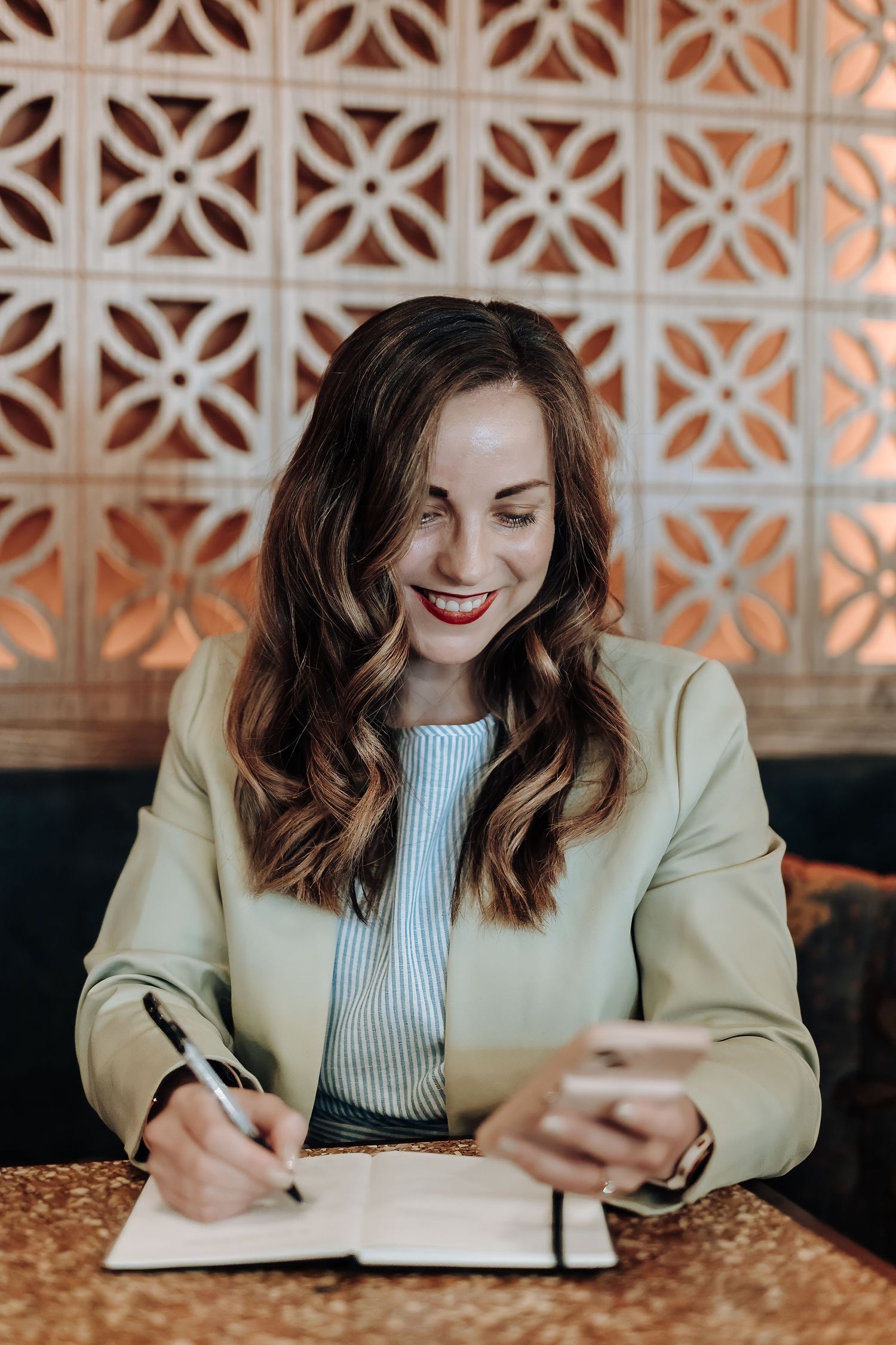 A sequence of images showing someone writing and working at a desk while wearing a beige blazer.