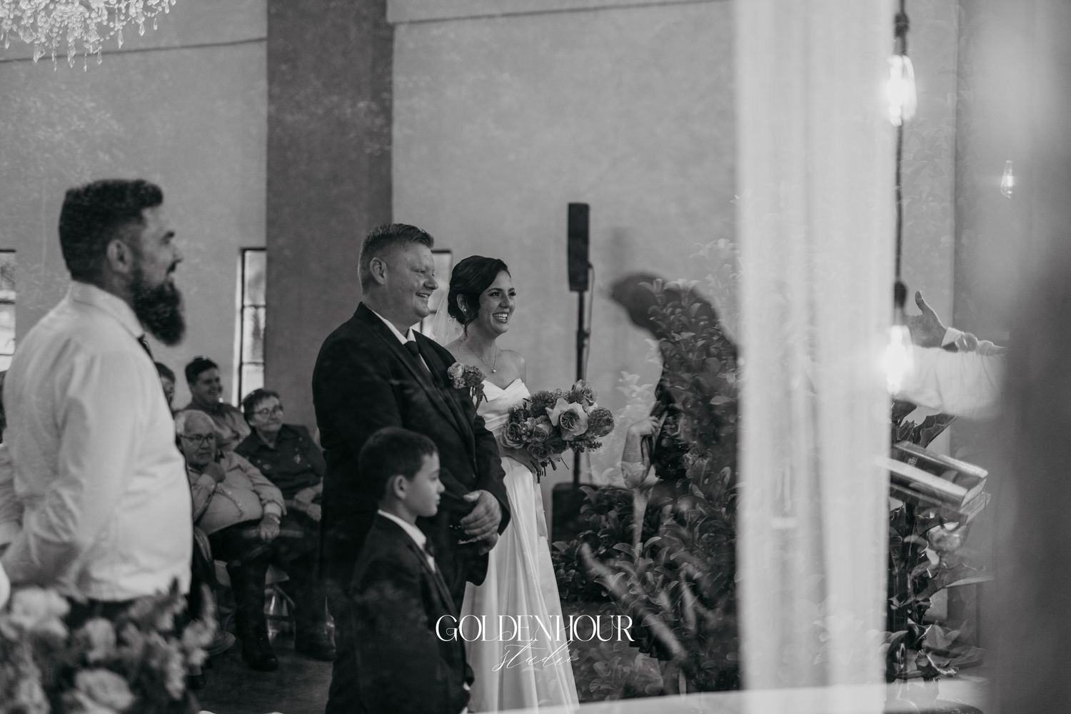 Black and white photo of bride and groom standing at the altar during their wedding ceremony.
