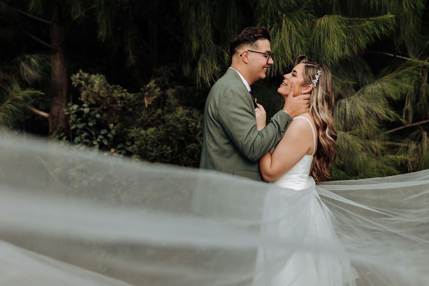 A romantic couple shares tender moments in a lush garden setting during their wedding photoshoot.