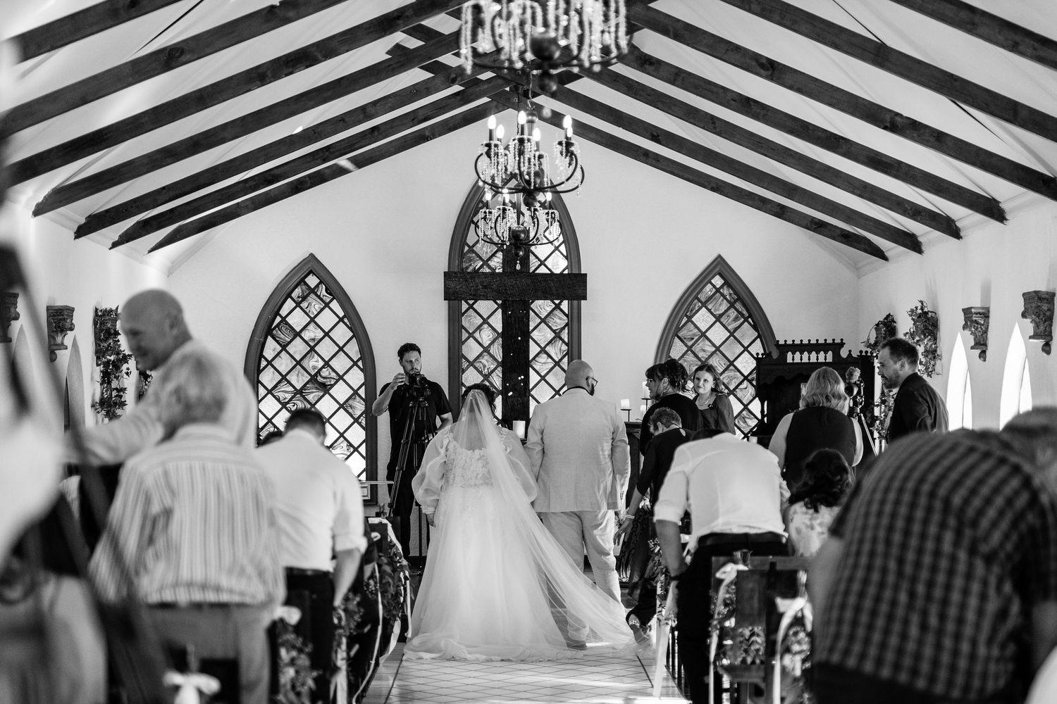 Wedding guests dance and celebrate on a black and white checkered dance floor in an elegant reception hall.