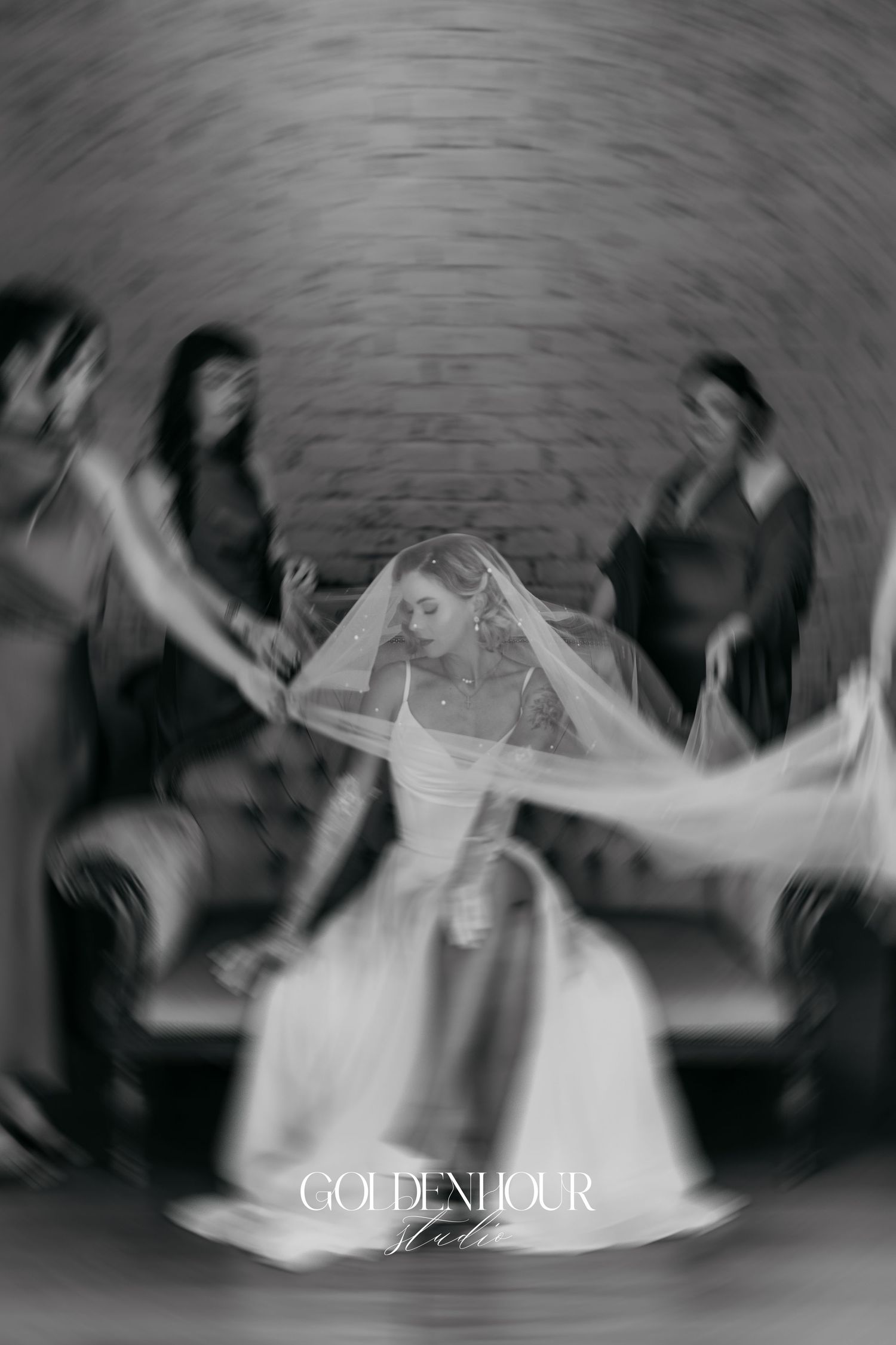 Motion-blurred black and white dance sequence showing celebration and movement at a wedding reception.