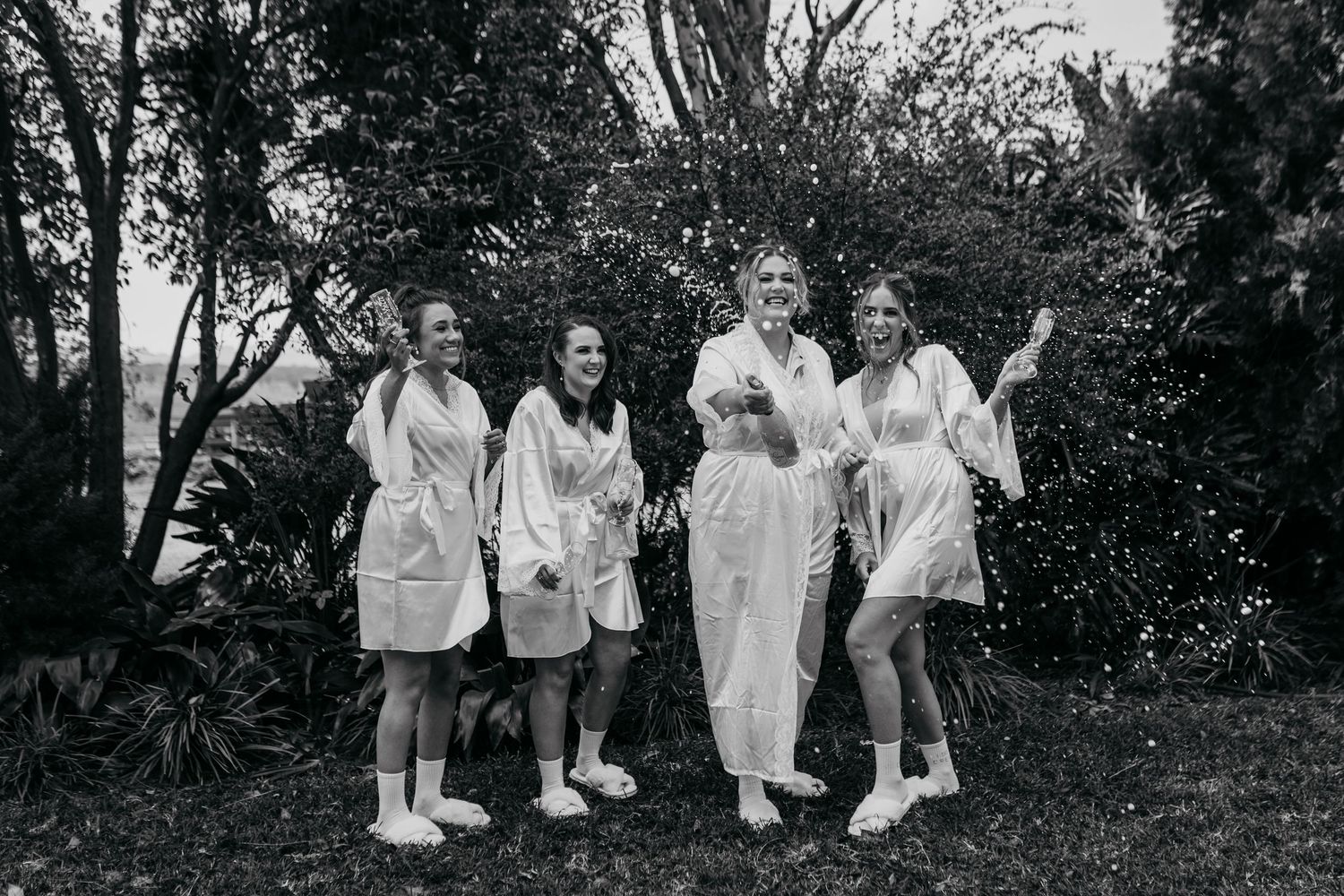 Group of nurses in white uniforms walking along a garden path in black and white vintage photograph.