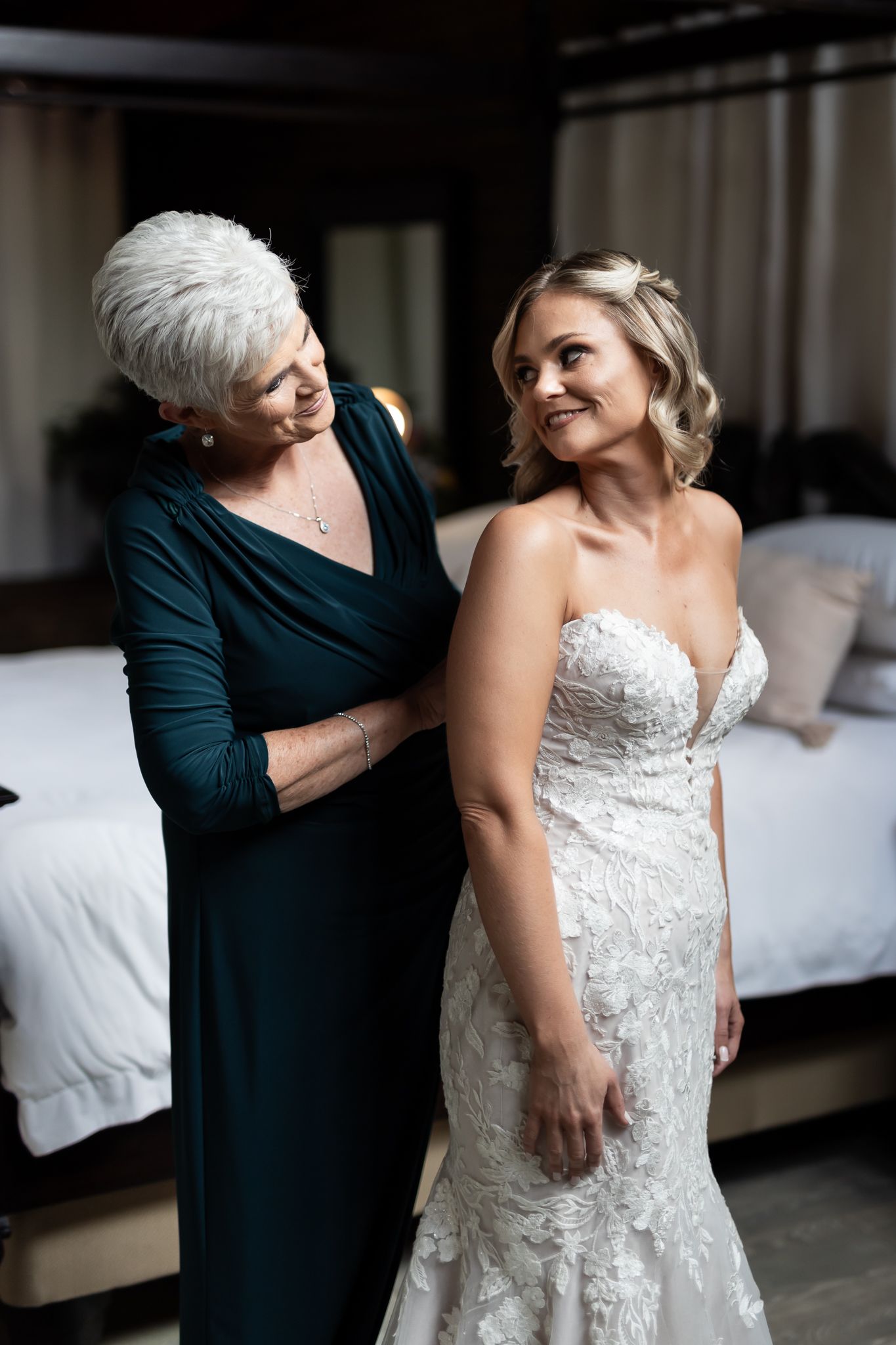 A touching moment between two women as they prepare for a special wedding day celebration.
