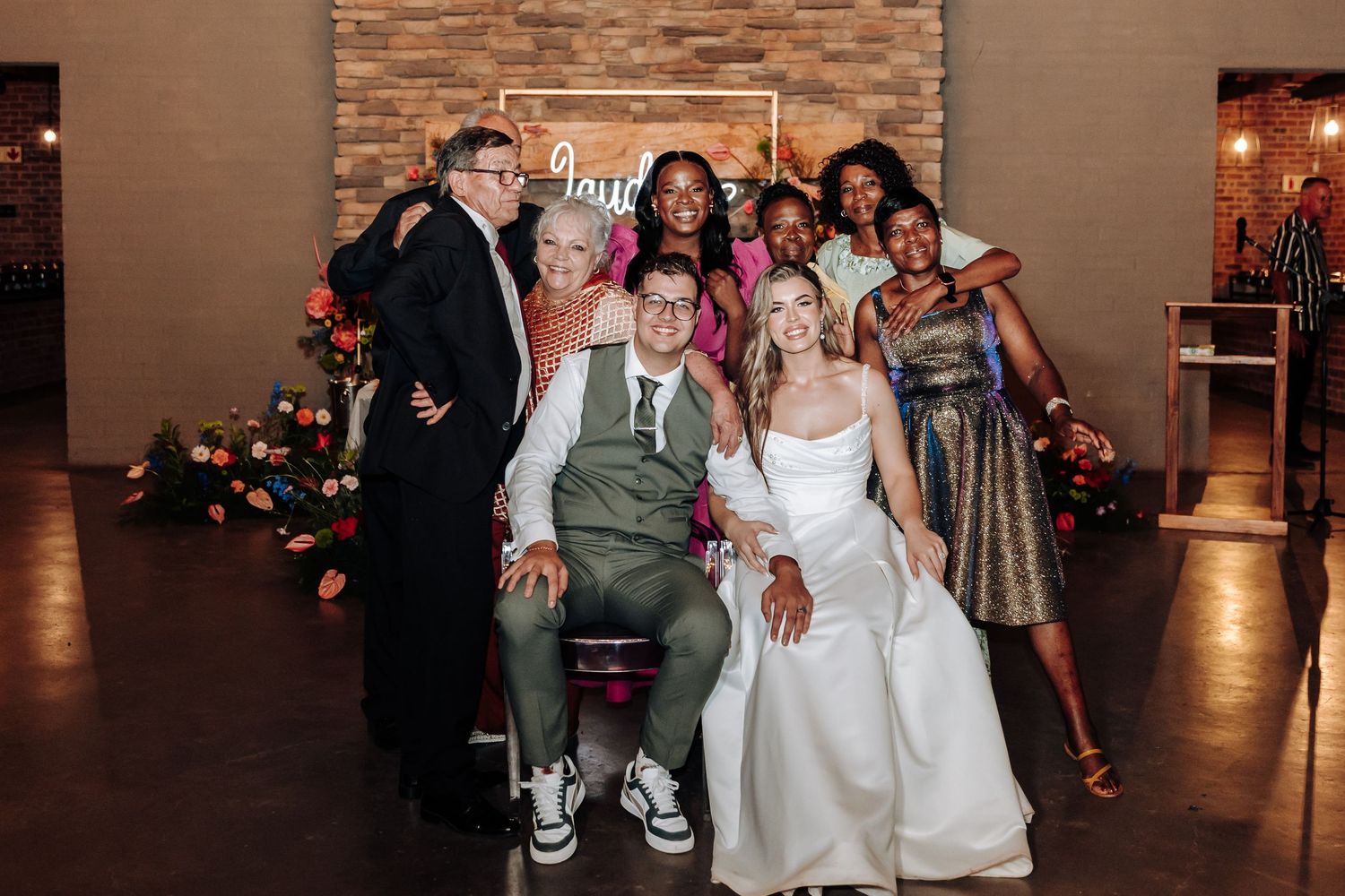 Wedding celebration in a modern venue with brick accent wall and dark flooring.
