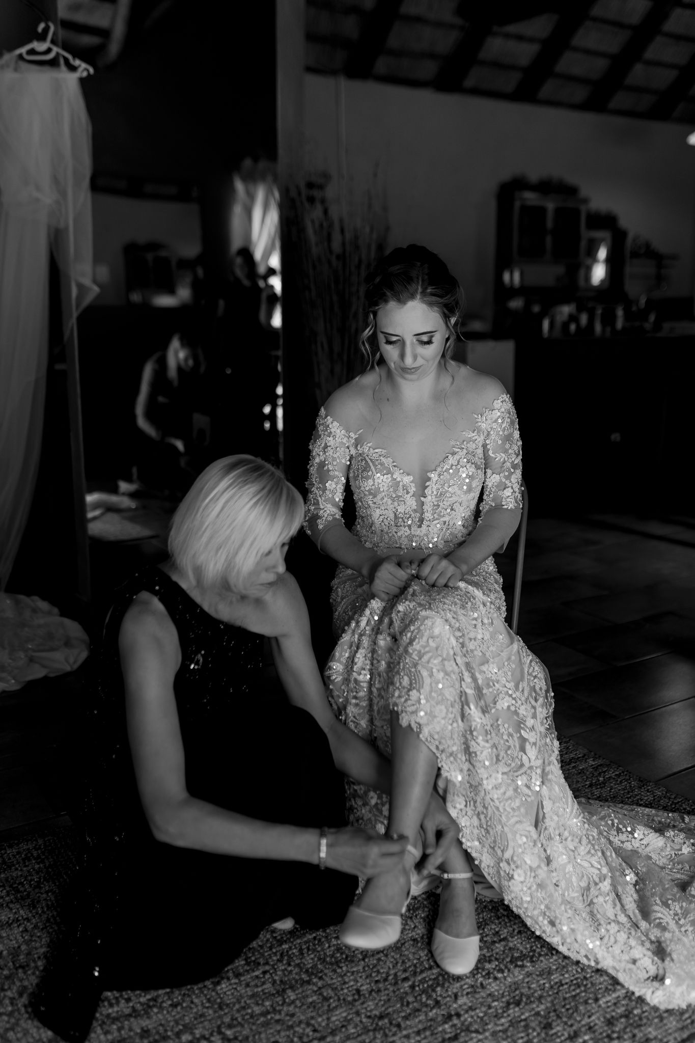 Black and white image of final wedding dress adjustments being made.