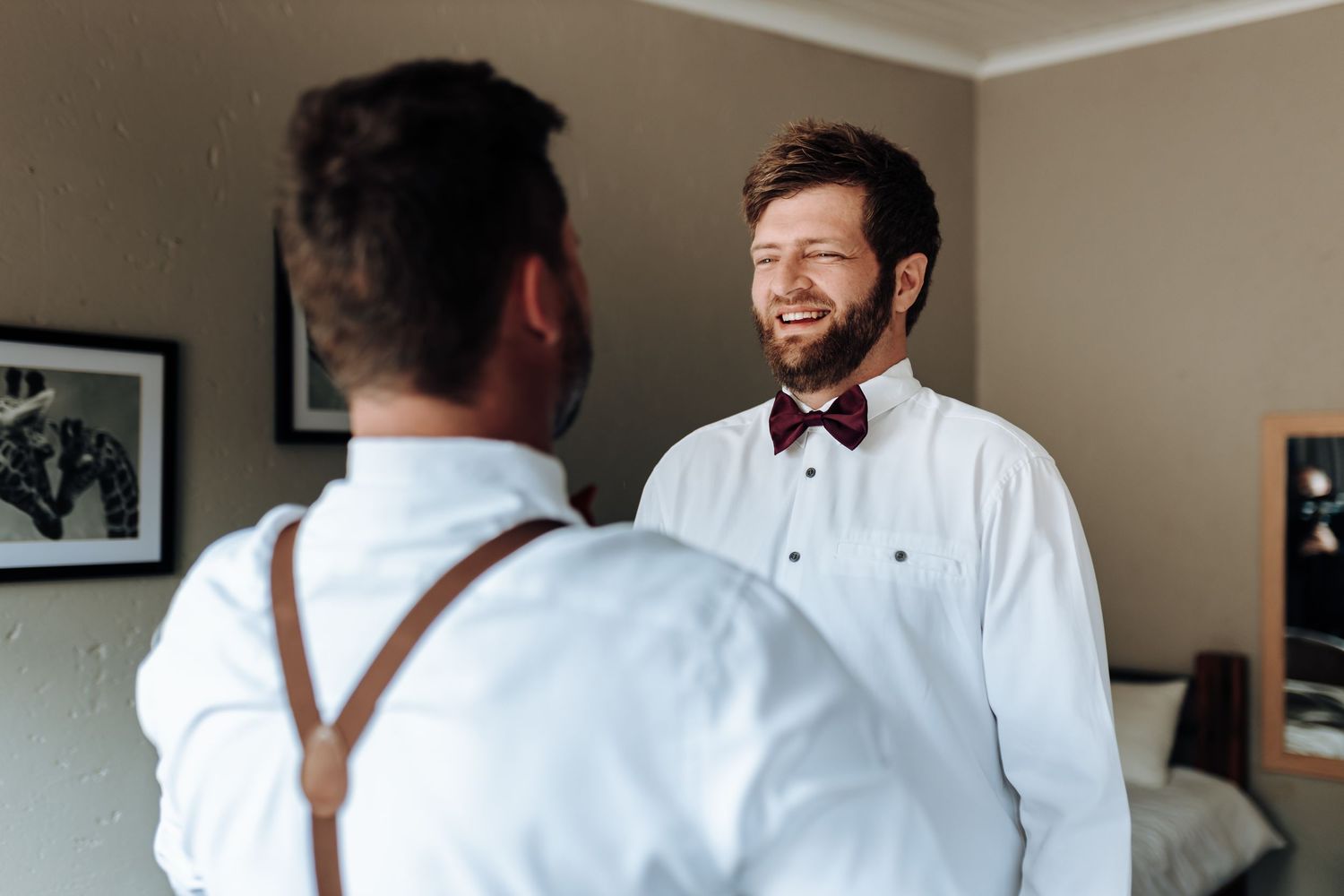 Two people sharing a lighthearted moment while dressed in formal white shirts.