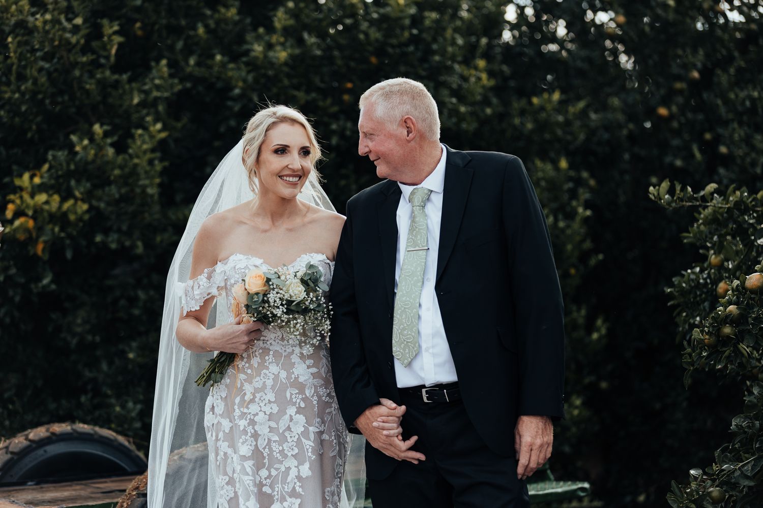 A heartfelt moment captured between bride and escort during an outdoor wedding ceremony.