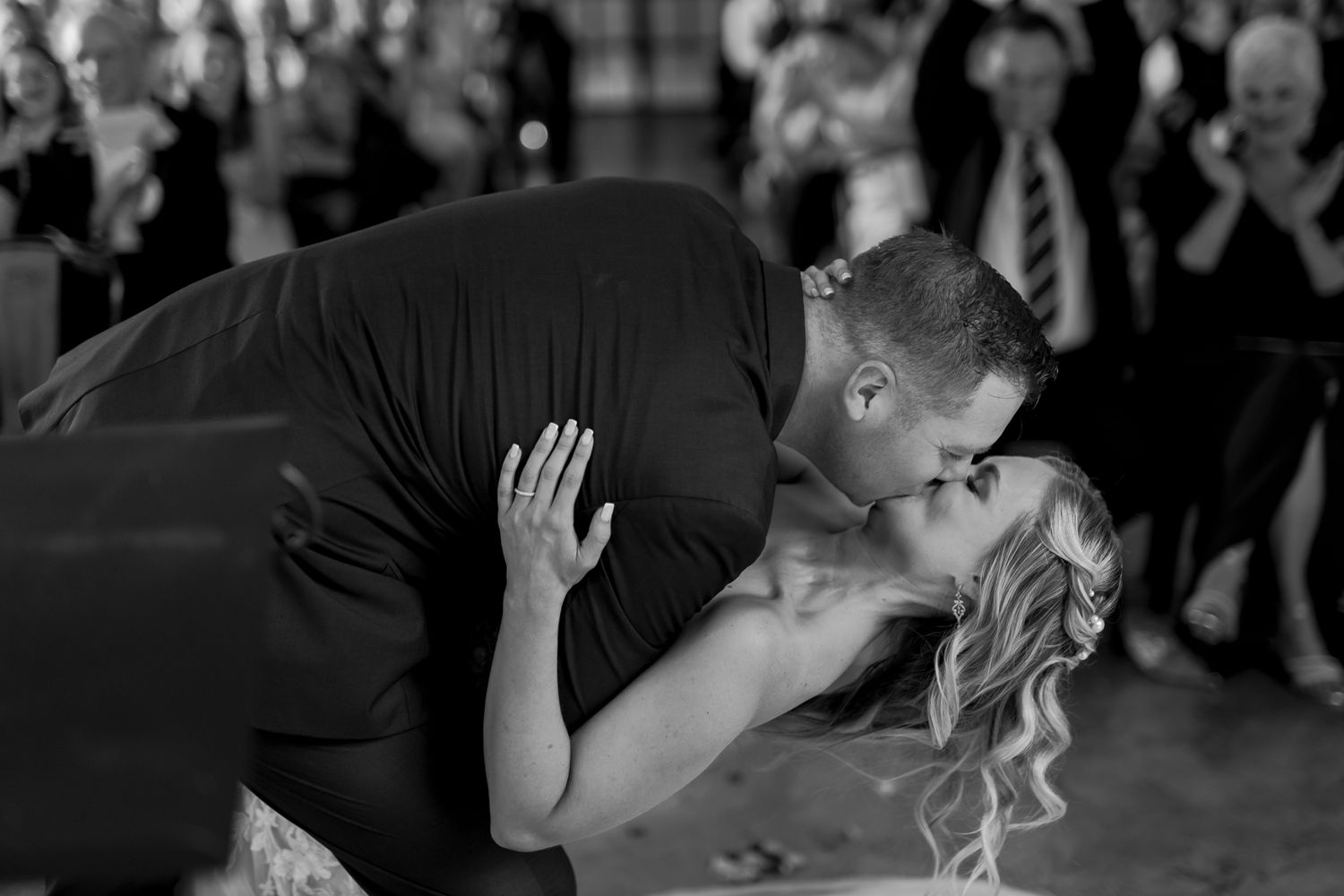 A romantic black and white photo of newlyweds sharing their first dance at their wedding reception.